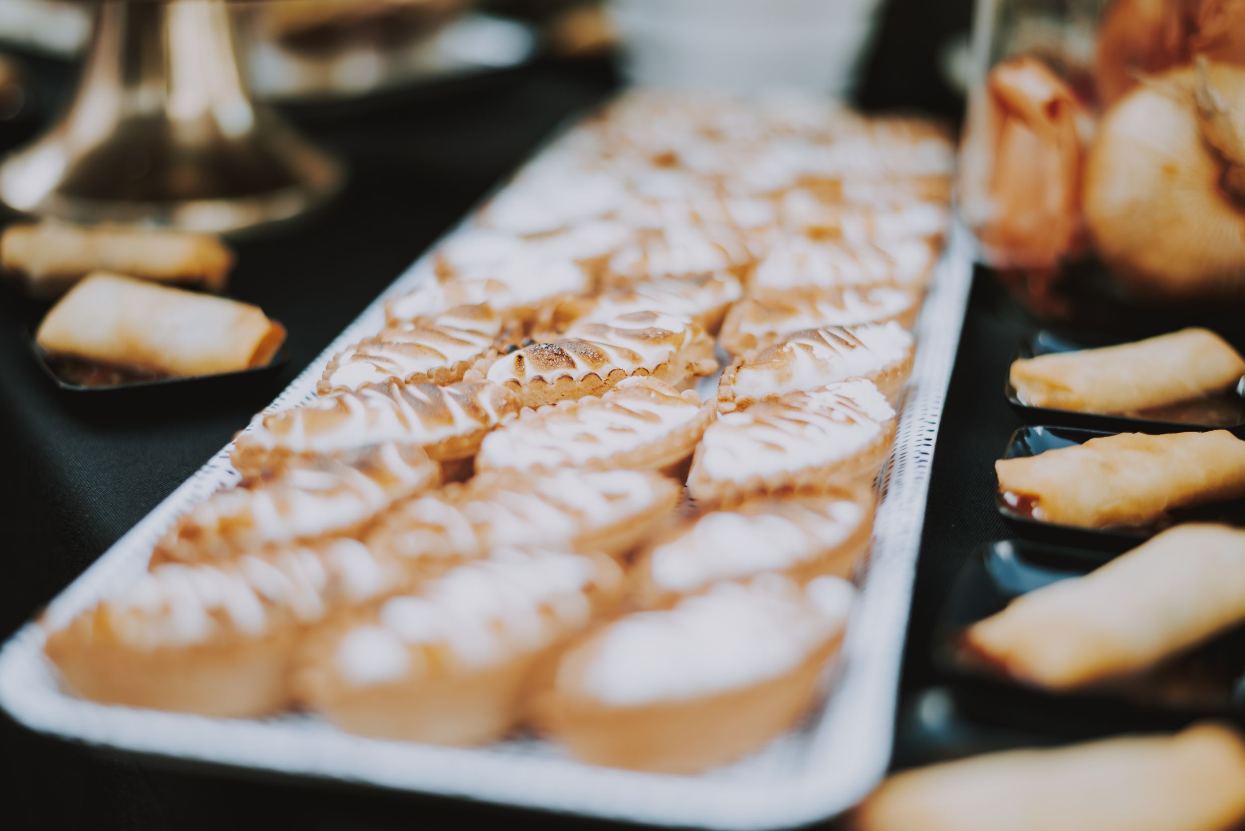 White desserts arranged in rows on a rectangular serving plate.