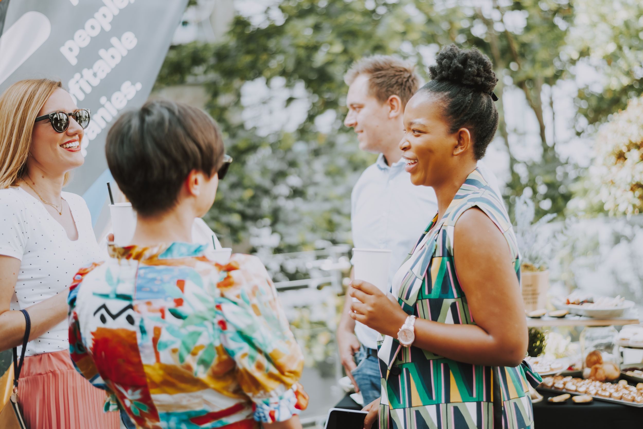 Group of people chatting and mingling at an outdoor summer party.