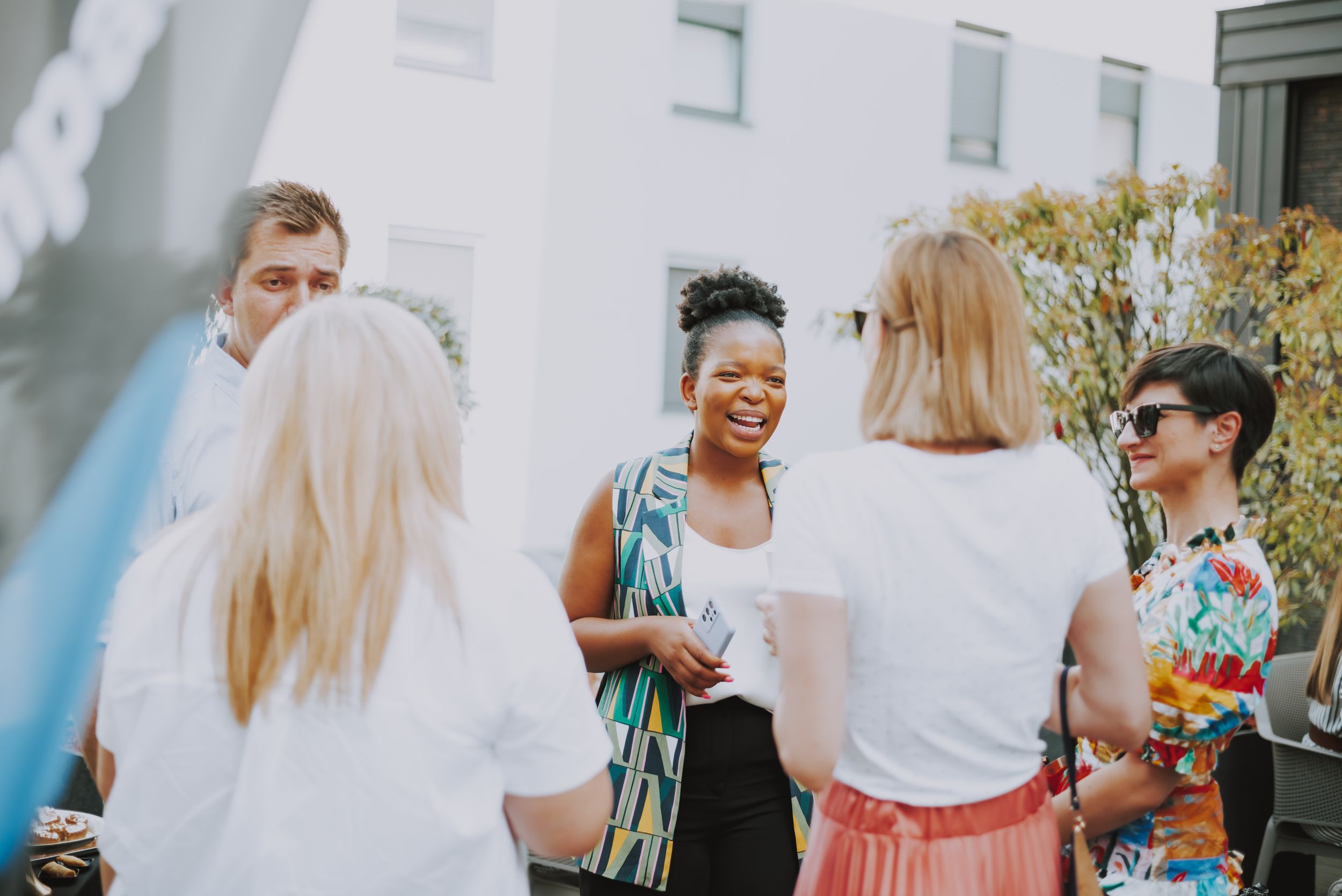 Friends gathered in casual attire enjoying conversation at an outdoor event.