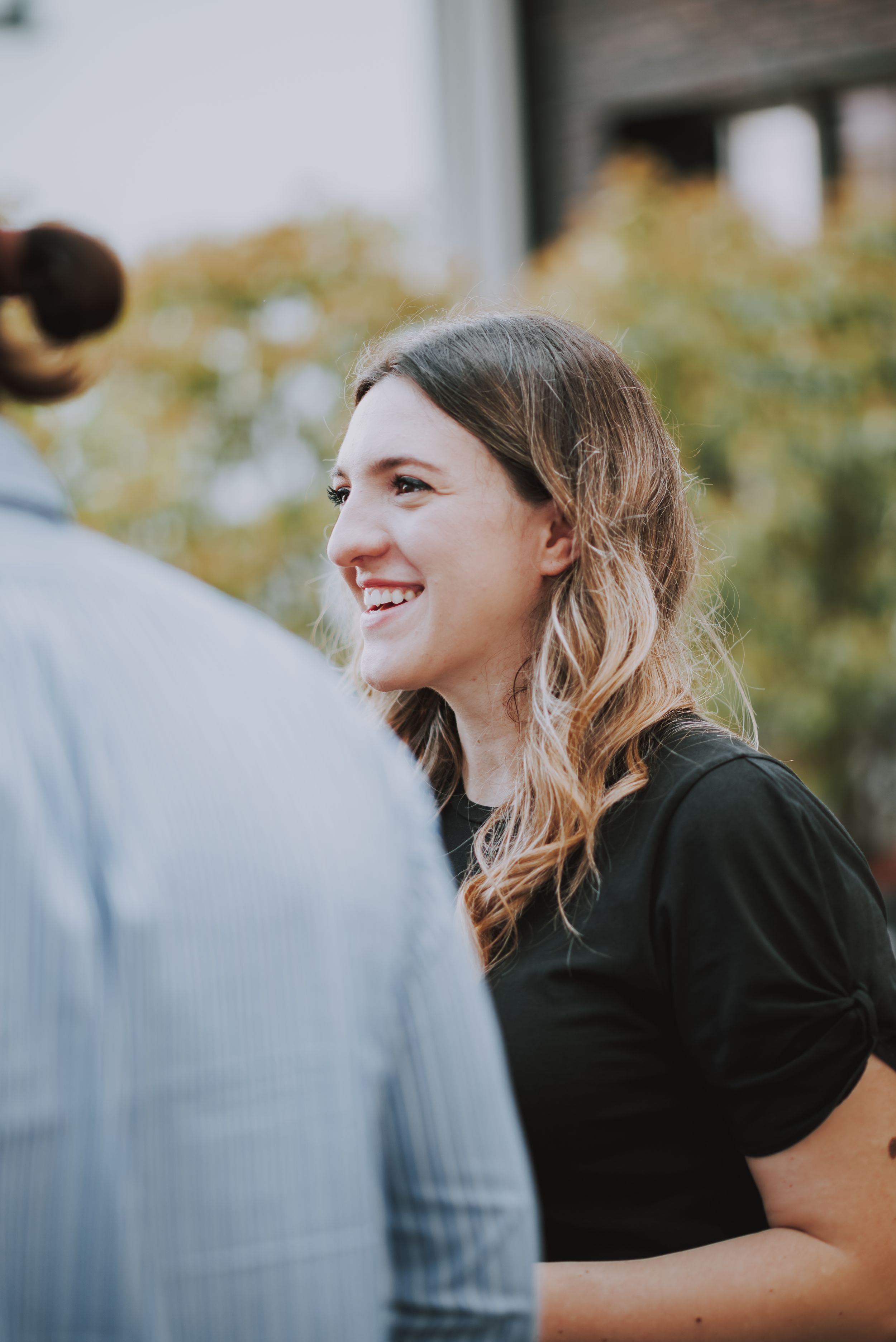 A candid moment captured at an outdoor summer party showing natural laughter and joy.