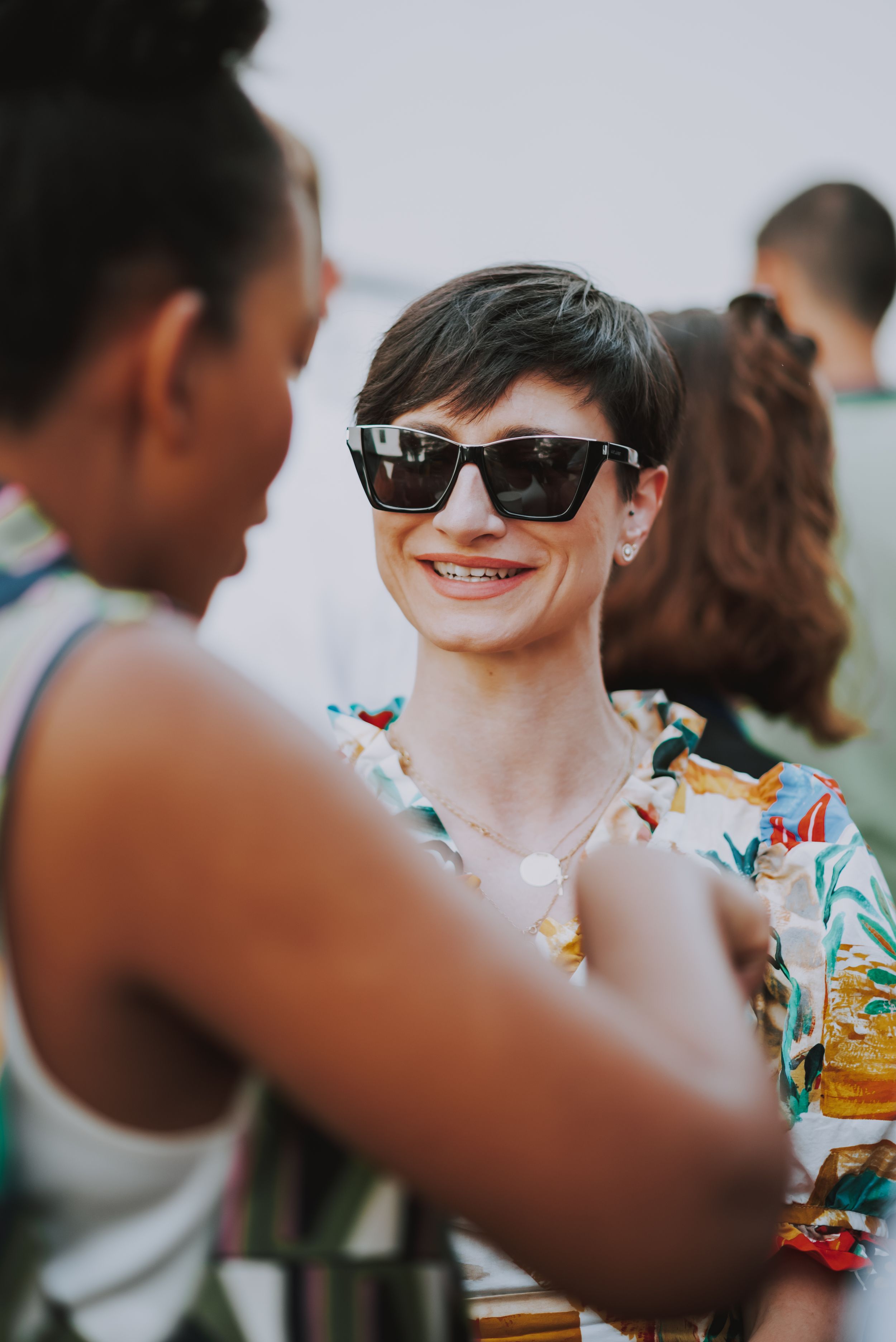 Two guests engaged in animated conversation at a summer outdoor party.