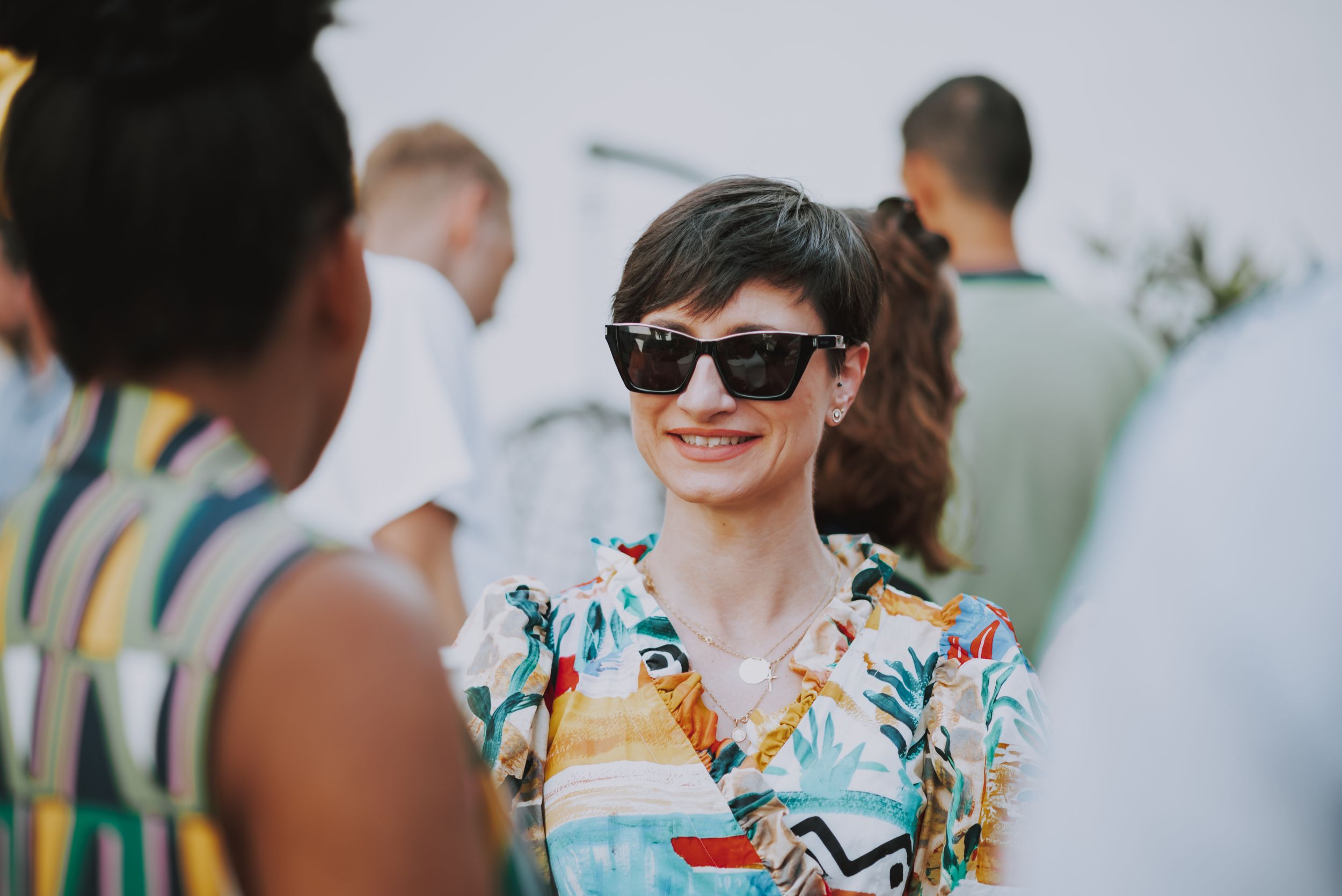 Attendee wearing a tropical print shirt and sunglasses at a summer social gathering.