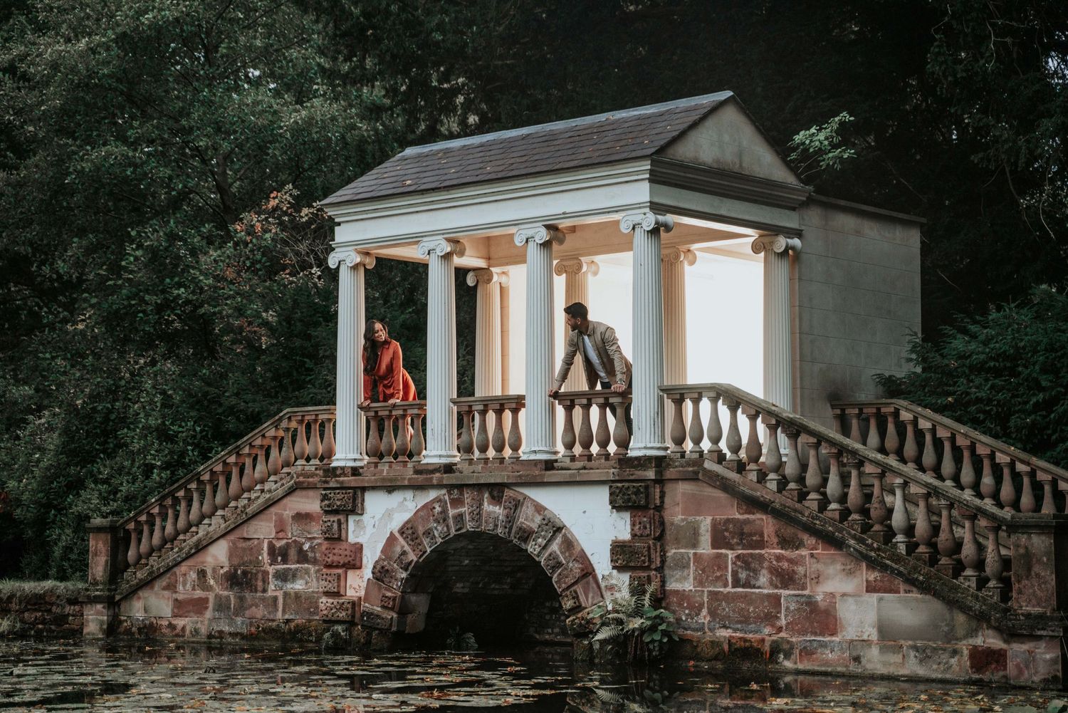 Hagley Hall engaged couple stand on historic bridged building