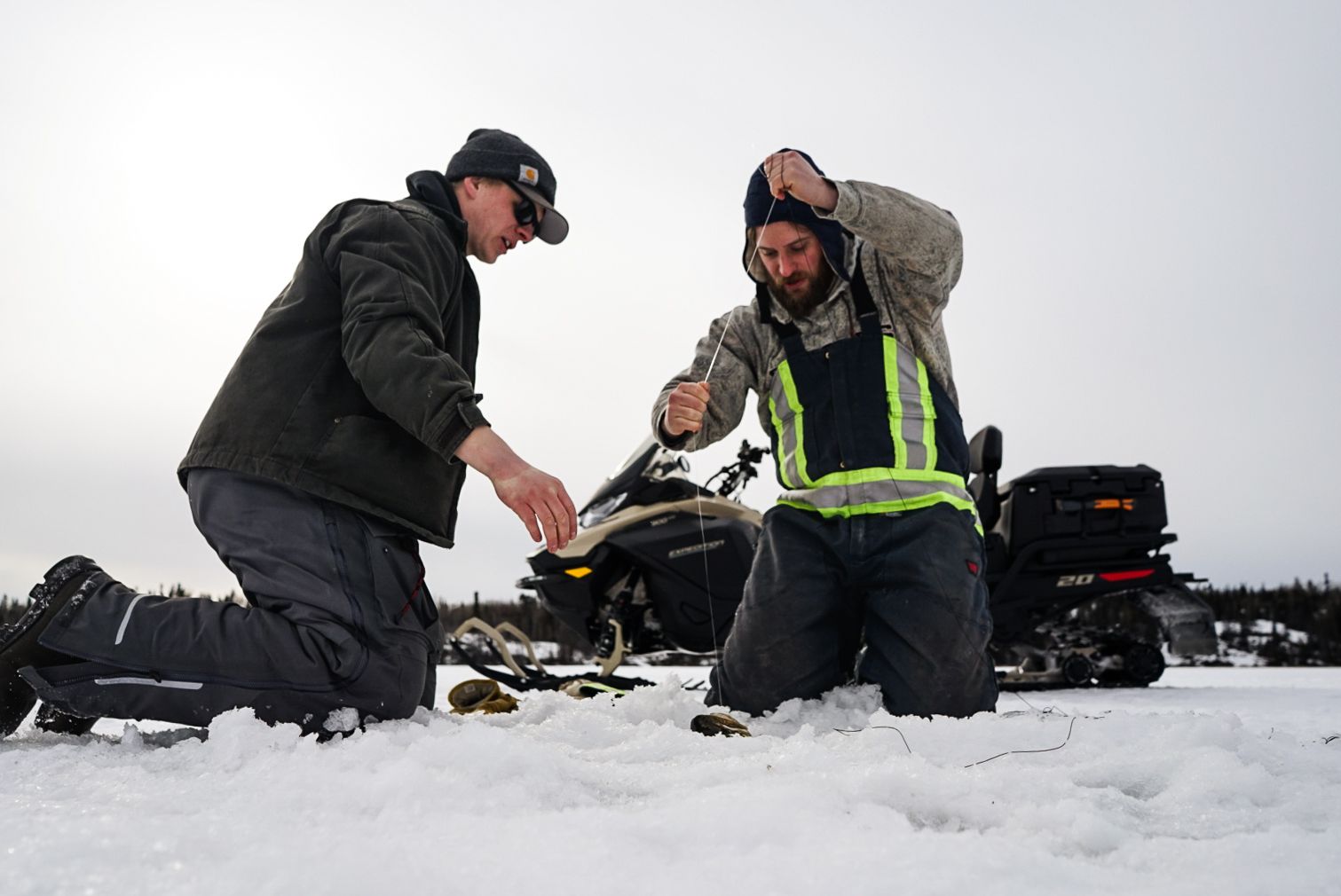 Group of ice fishers gathered on a frozen lake with their equipment and gear.