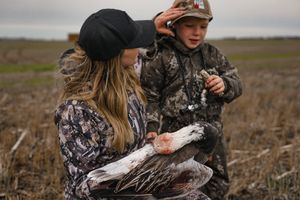 Hunters in camouflage gear moving through natural terrain during a hunting expedition.