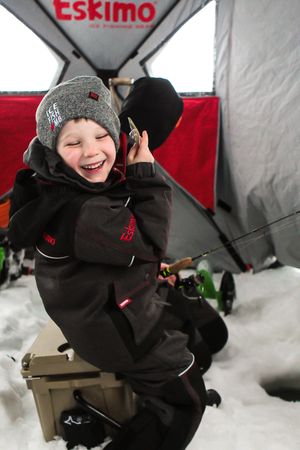 Ice fishing shelter with Eskimo branding in winter conditions.