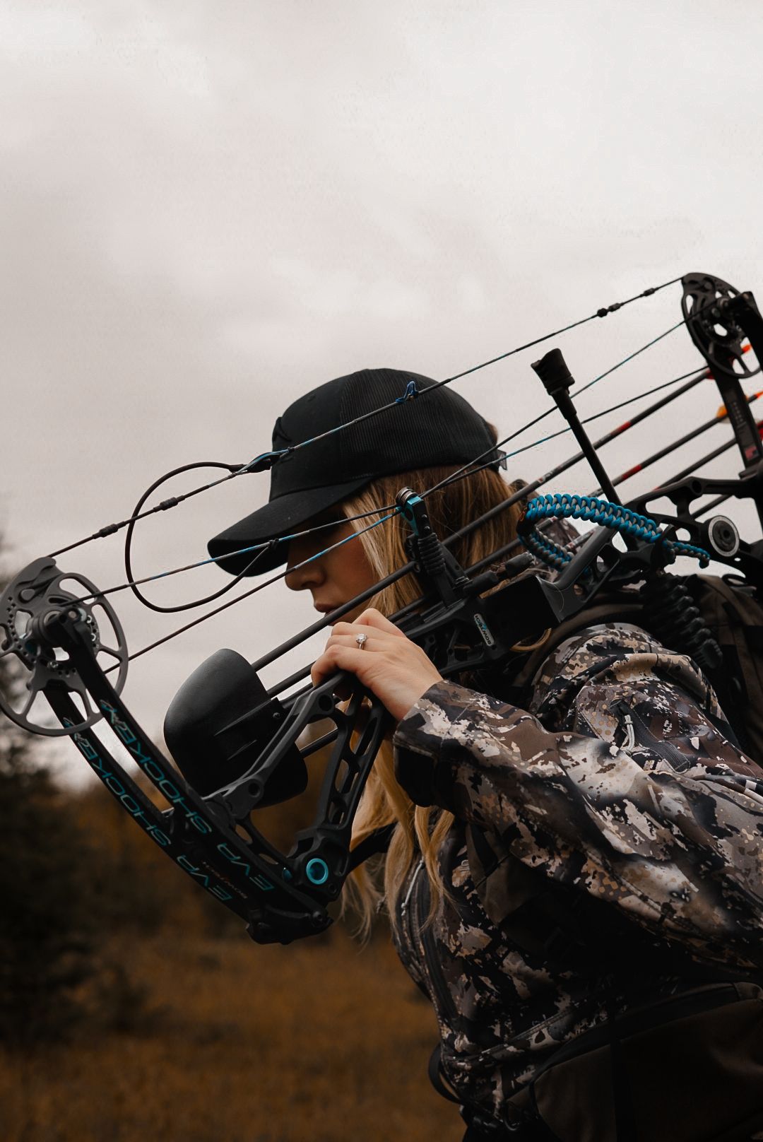 Bow hunter in camouflage gear aiming compound bow during hunting season.