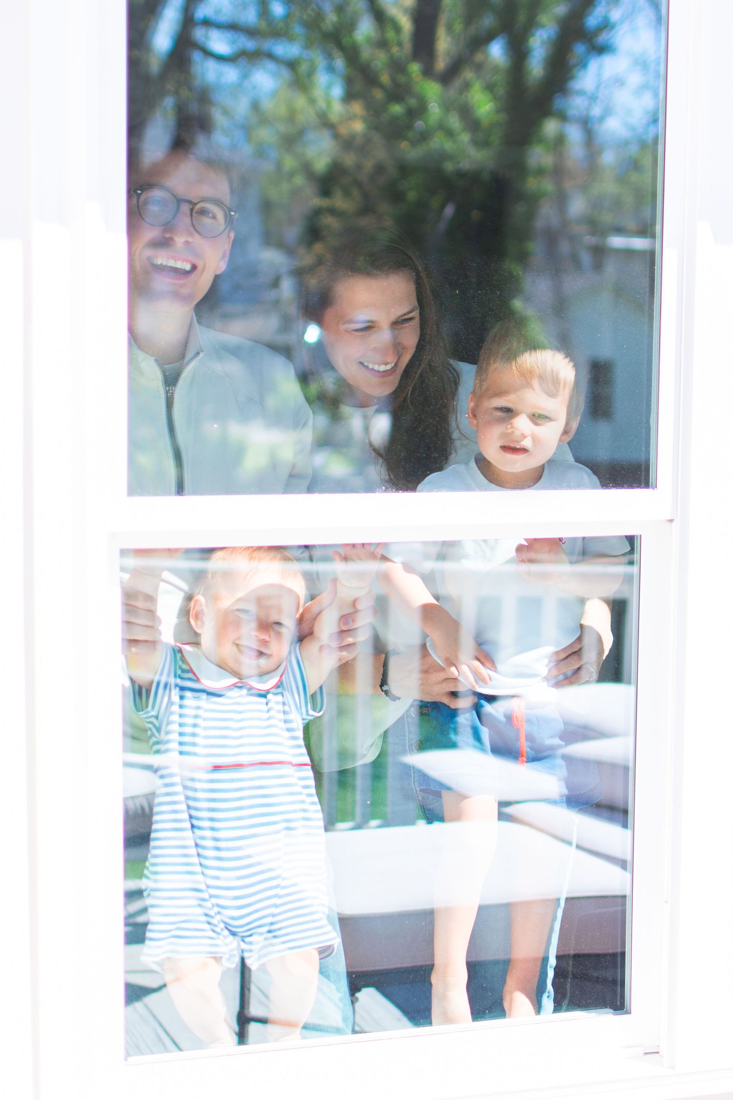 Looking in from the outside, a family snuggles in their Ardmore Historic District bedroom.