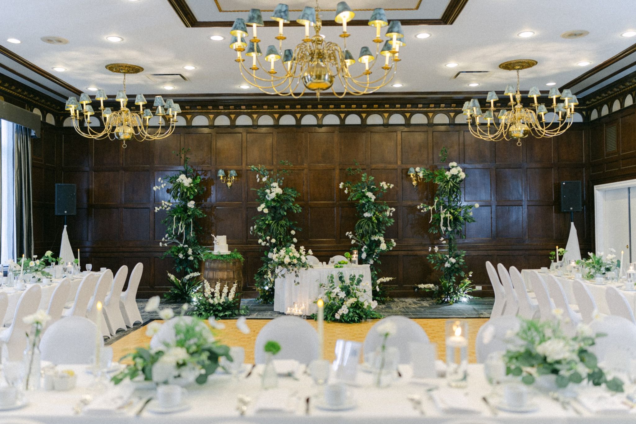 luxury wedding reception setup with long tables, chandeliers, and floral styling in Regina wedding venue