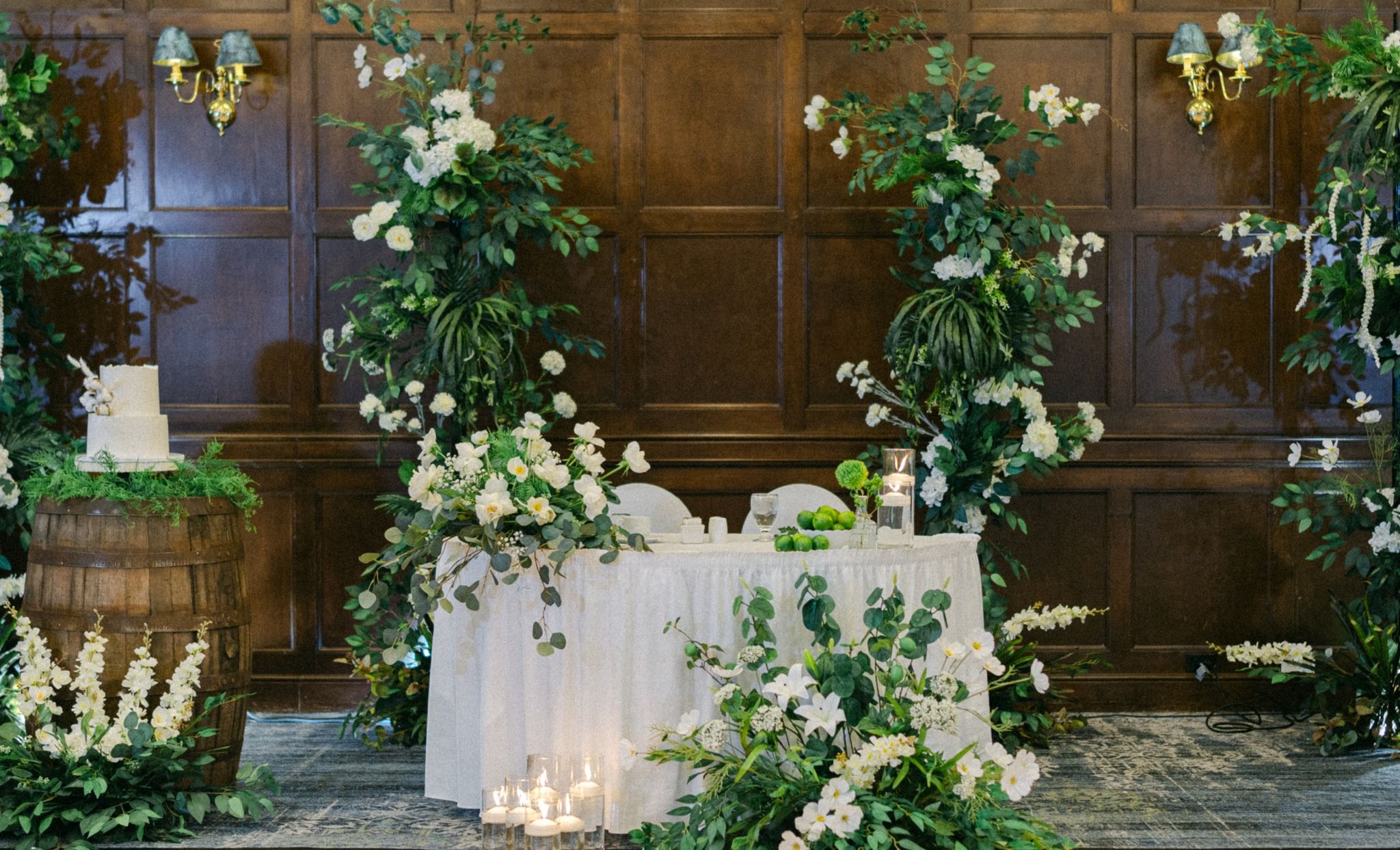 luxury wedding head table with greenery, white florals, and candle styling in regain wedding decor