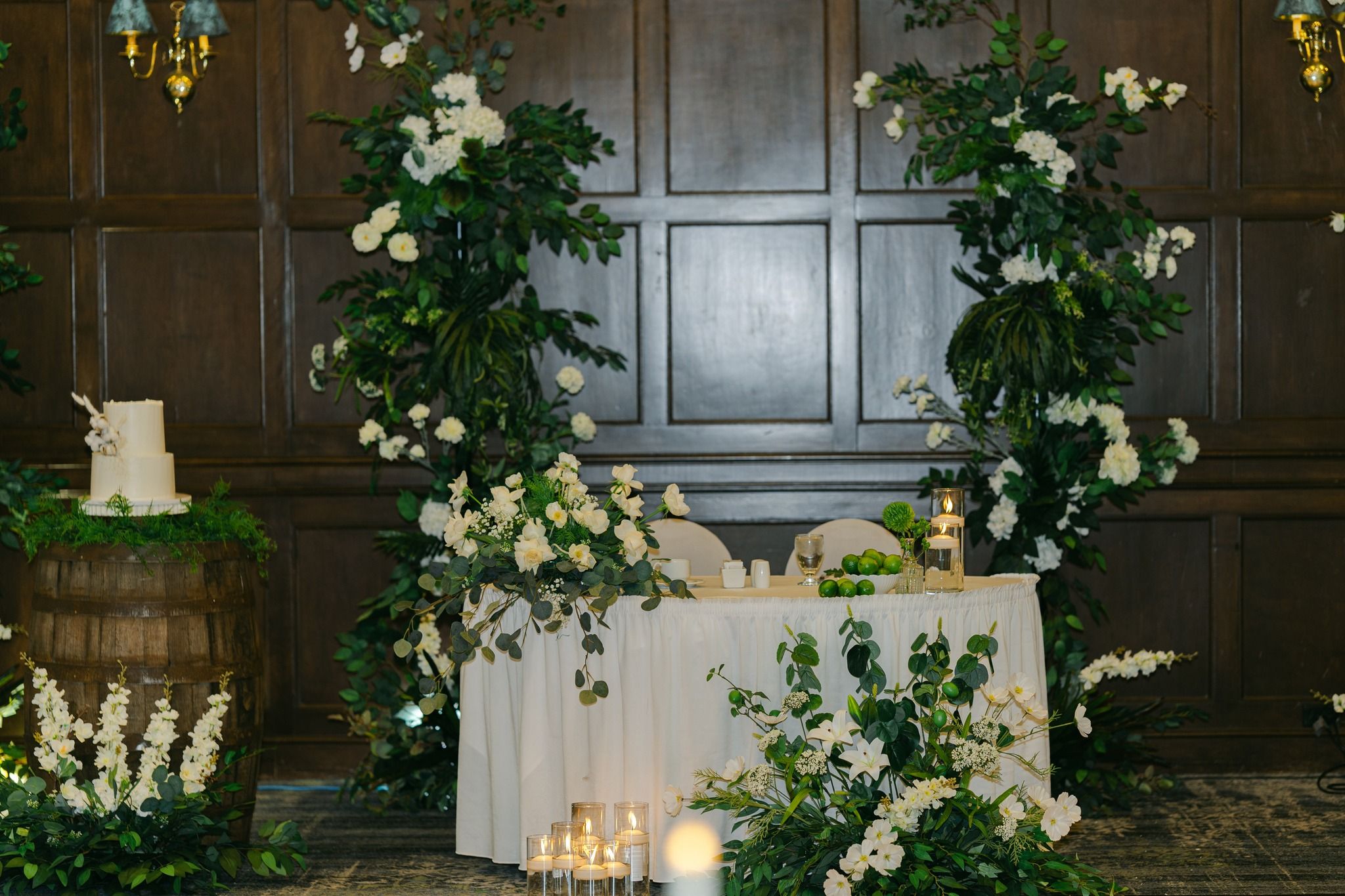 luxury wedding head table backdrop with greenery, candles and floral arrangements in Regina wedding styling