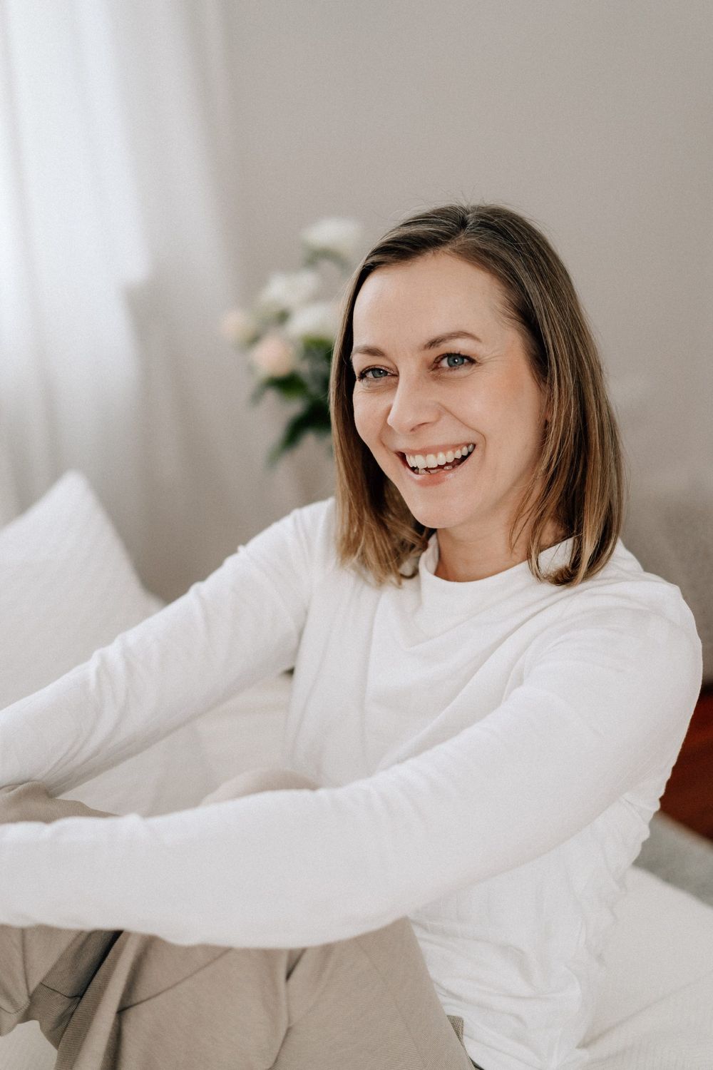 Portrait series showing joyful expressions in a soft white sweater against neutral background.