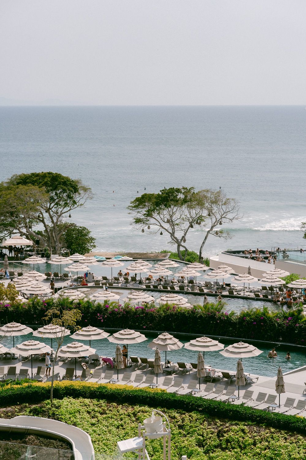 Oceanfront resort view with umbrellas and lounge chairs overlooking the beach.