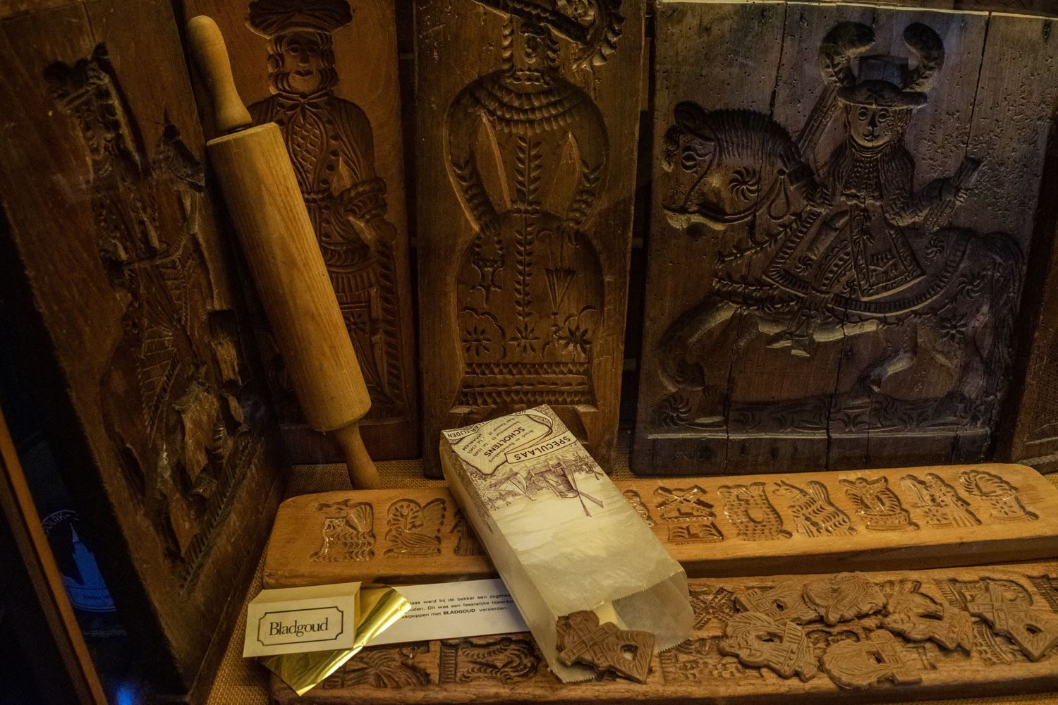 Antique woodworking tools and carved wooden panels displayed in a rustic setting.