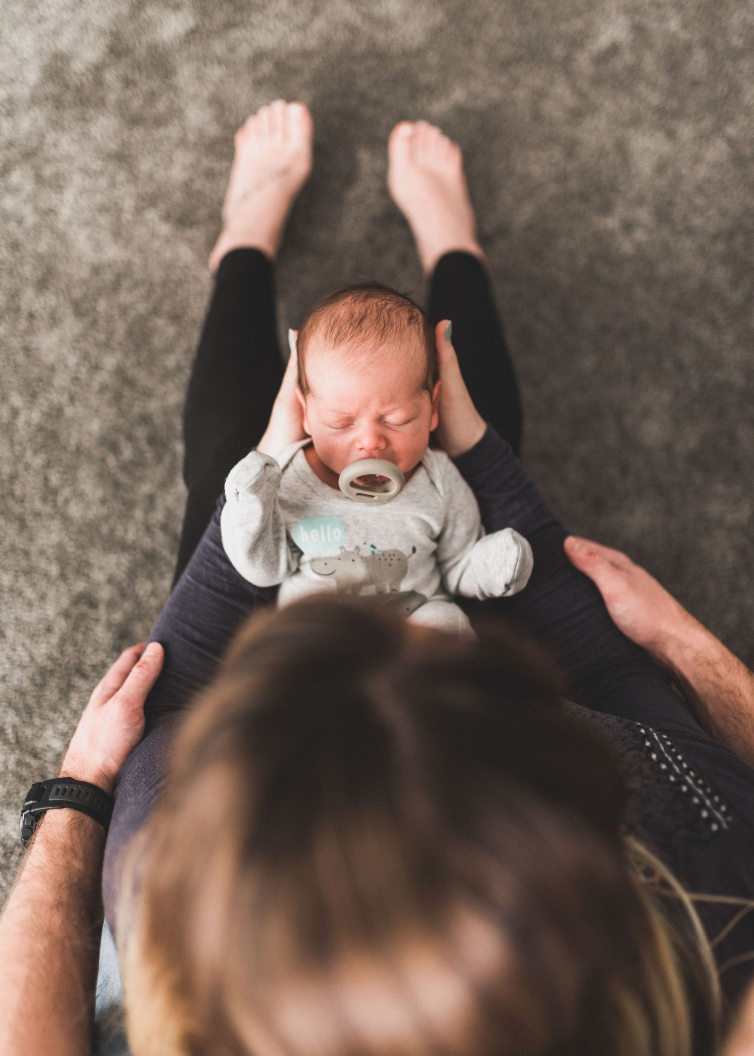 Baby sucking on binki in mothers lap
