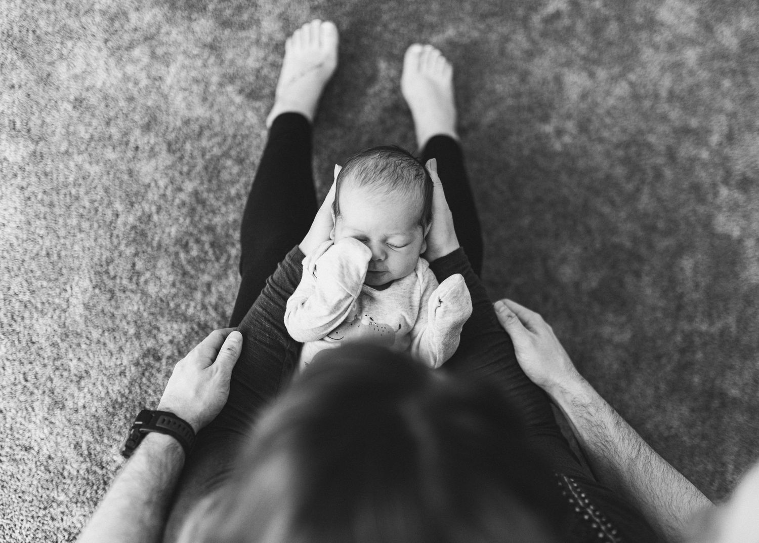 Greyscale image of baby in mothers arm image taken from above
