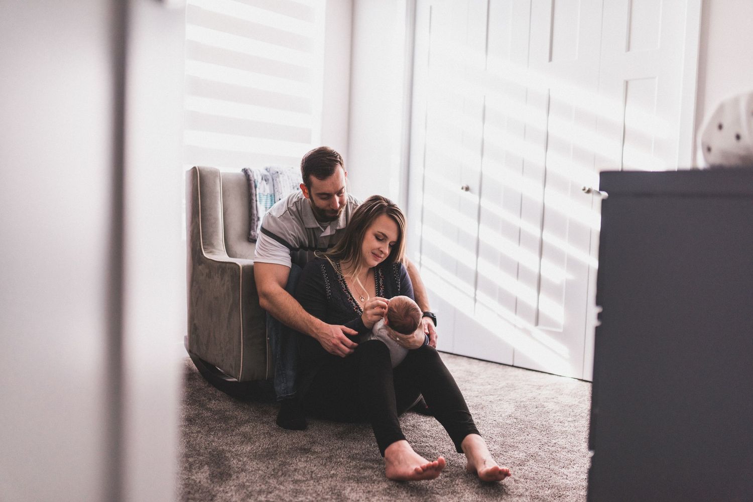 Parents in the nursery snuggling newborn baby