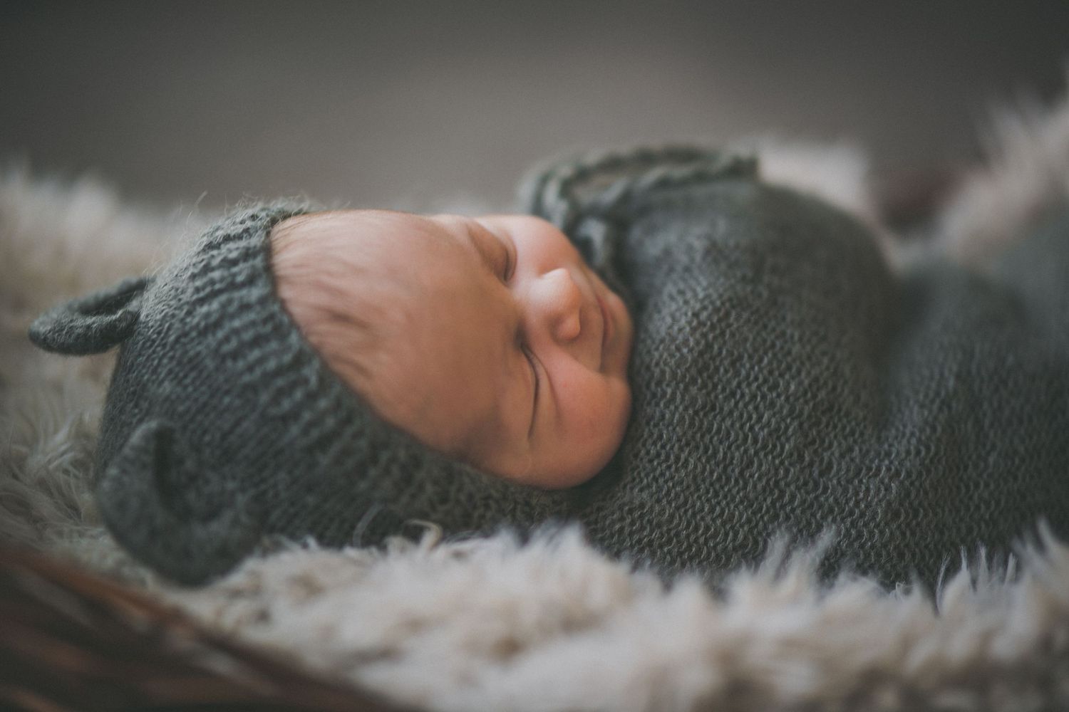 Smiling sleeping newborn in bear cap
