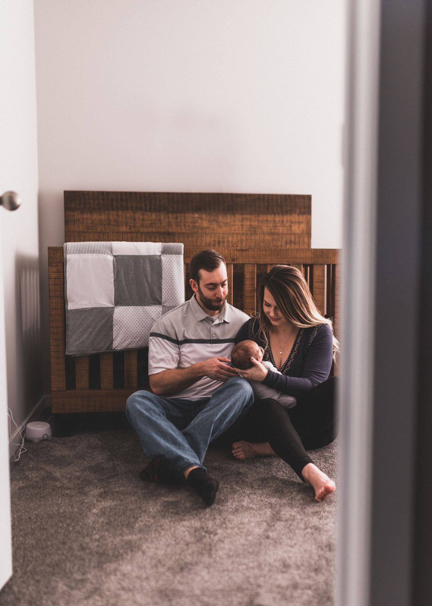 New Parents looking at baby next to crib