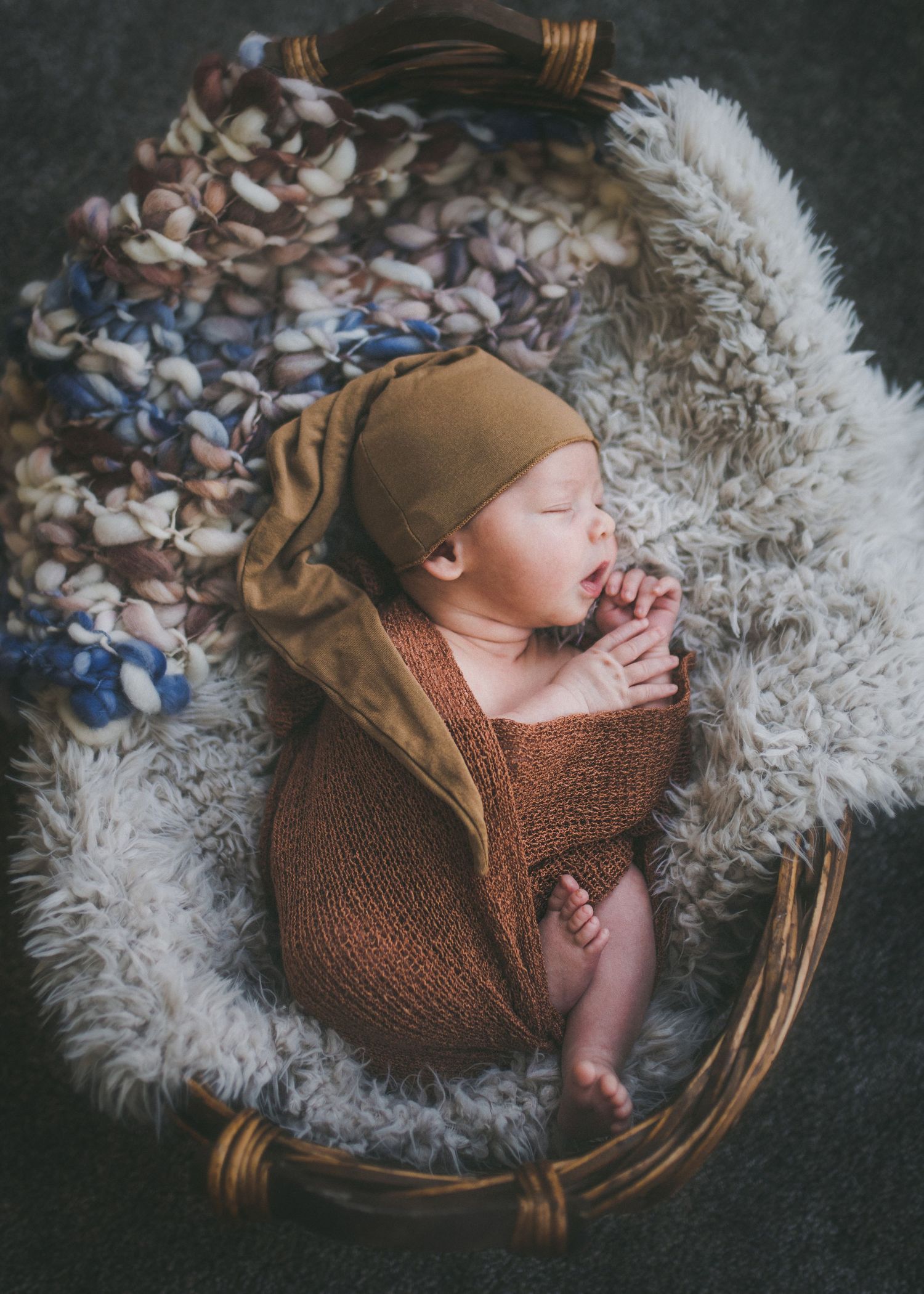 Sleeping newborn in brown cap and swaddle