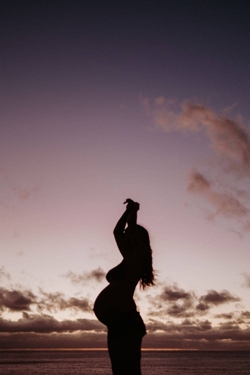 Silhouette of pregnant woman during a natural sunset maternity photography session at Maslin Beach, South Australia