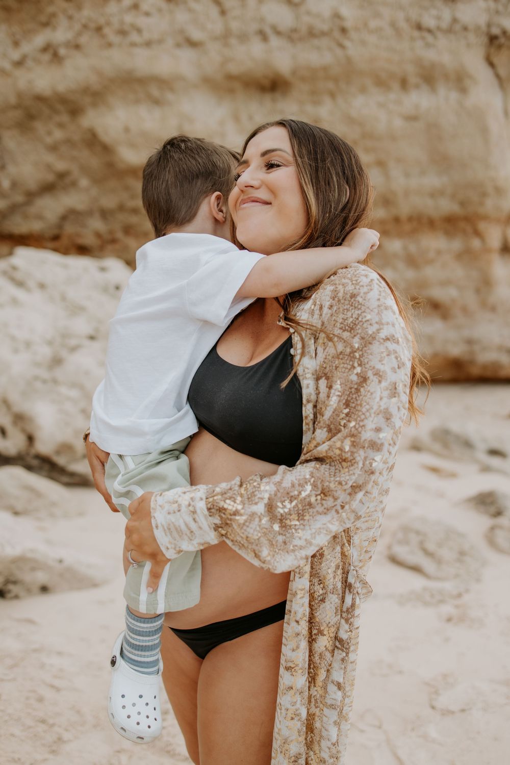 Expectant mother holding her first born during a natural sunset maternity photography session at Maslin Beach, South Australia