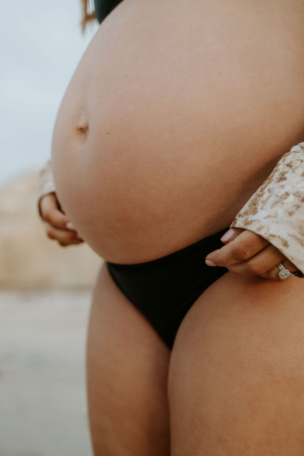Detail shot of pregnant belly during a natural sunset maternity photo session at Port Willunga, South Australia