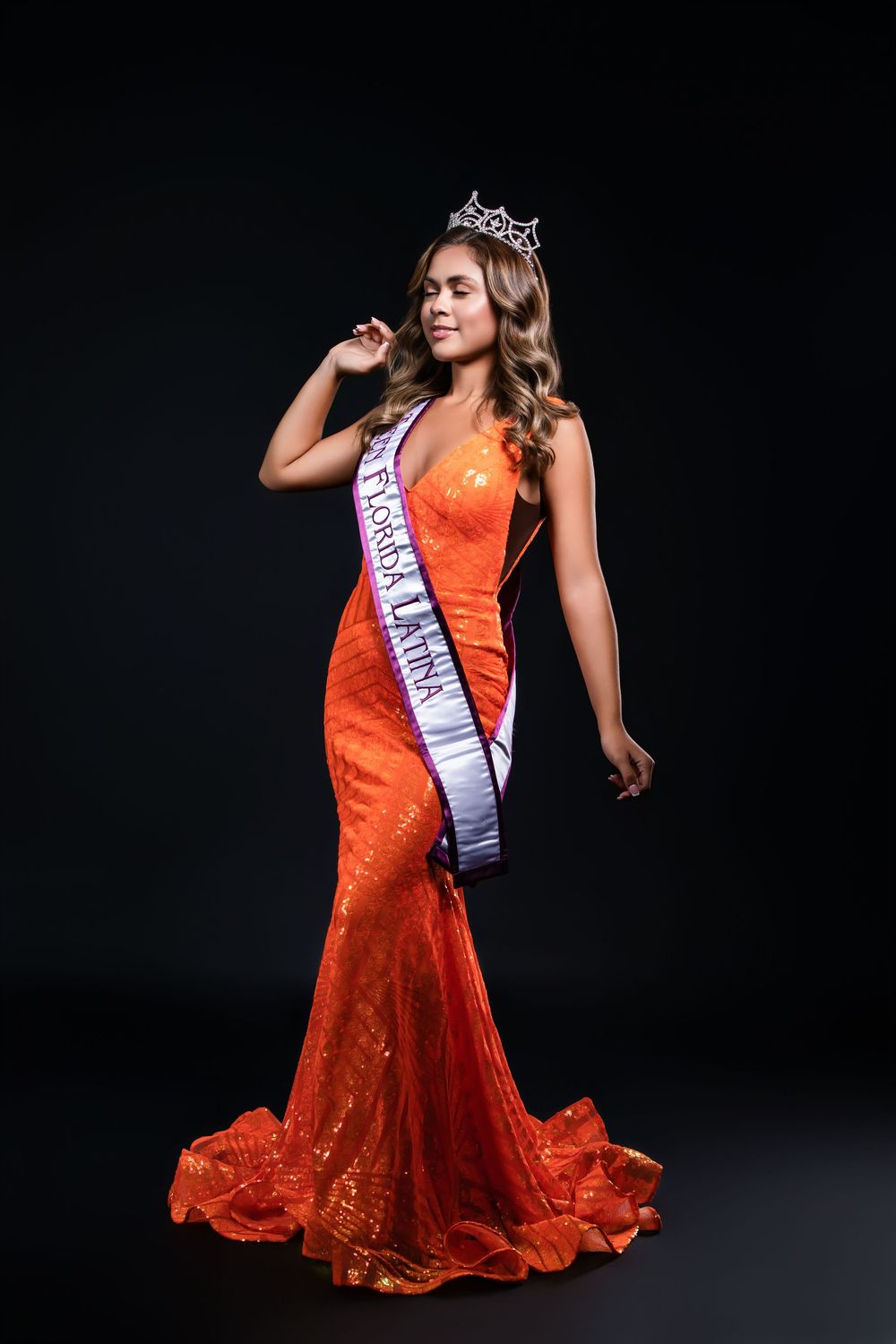 Full-length view of orange sequined pageant gown with dramatic flare.