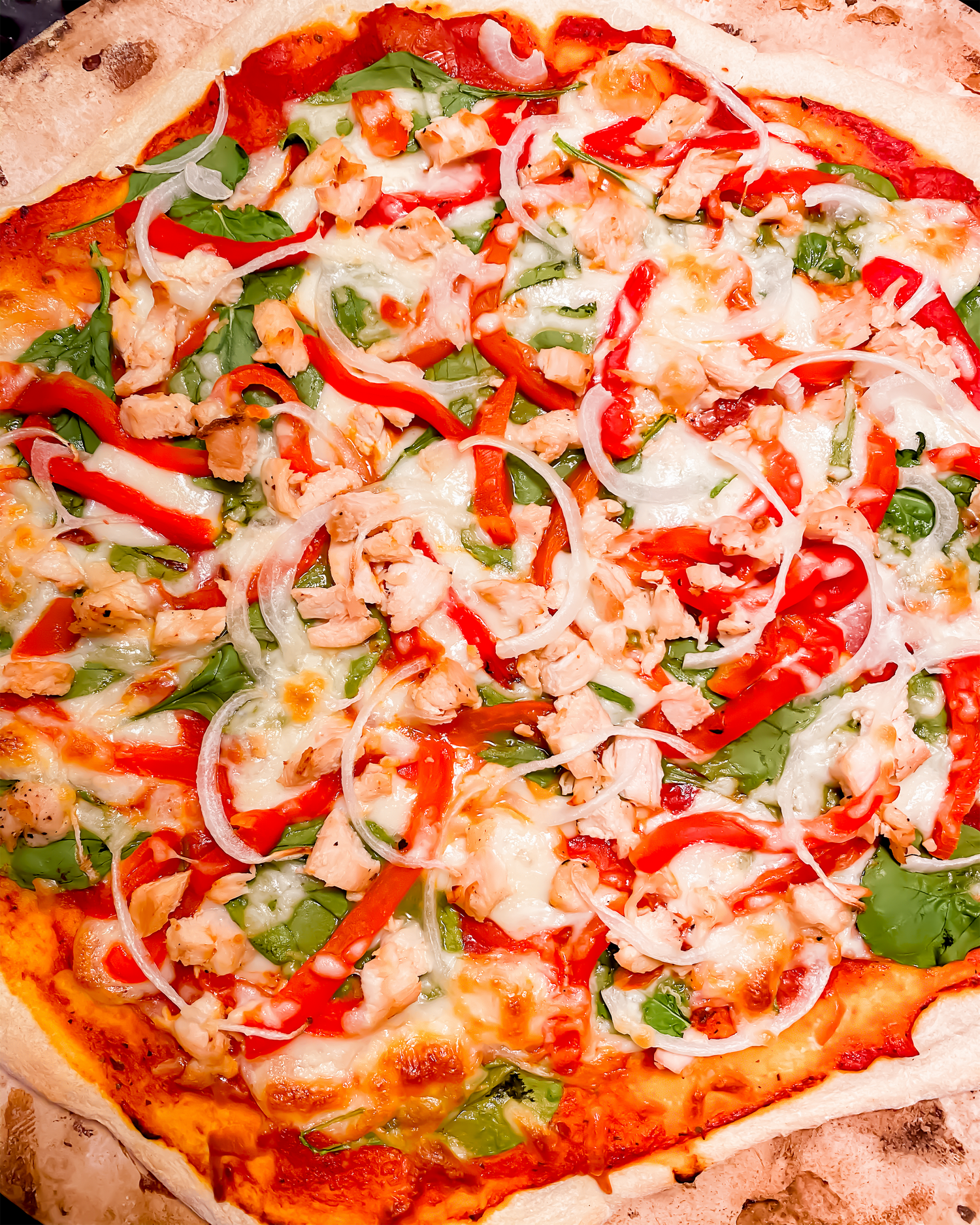 Homemade pizza with tomato sauce, mozzarella, and fresh basil leaves.