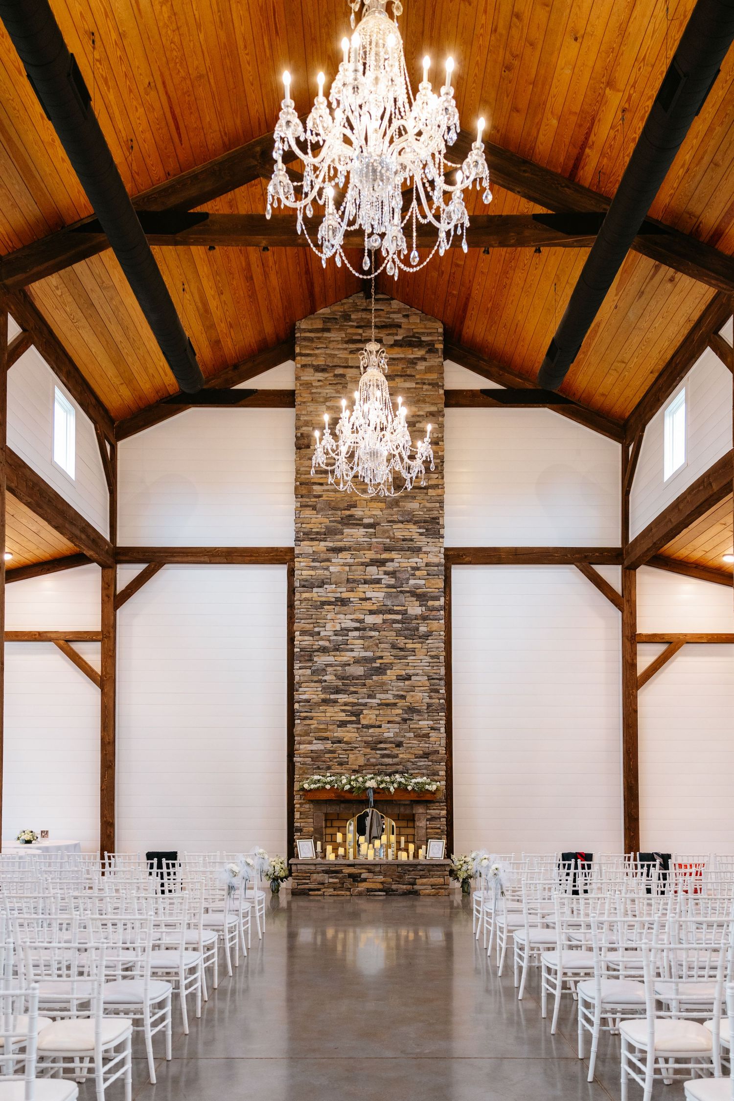 Elegant wedding chapel with vaulted wooden ceiling, crystal chandeliers and stone fireplace.