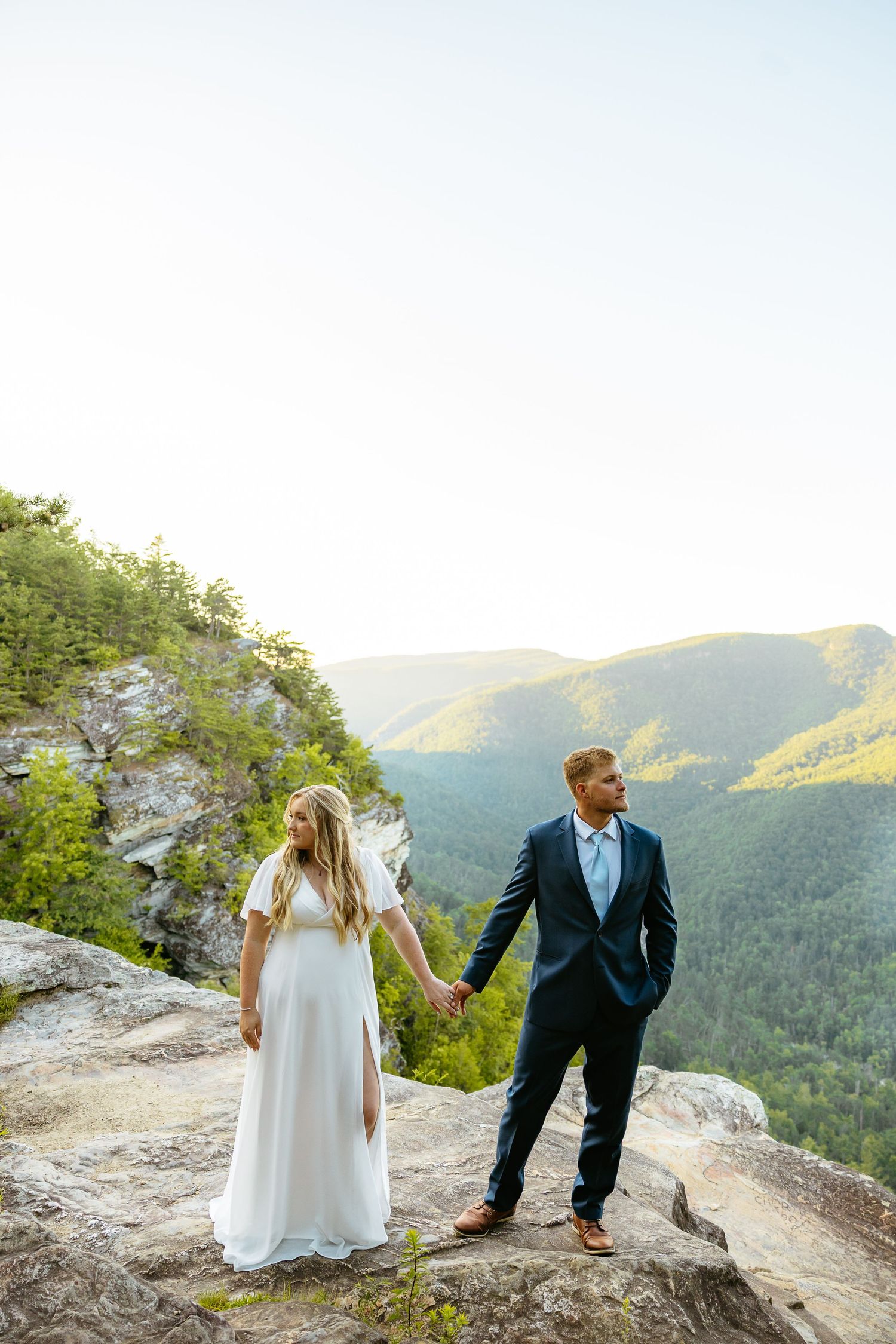 Wedding photos taken at a scenic mountain overlook showing couple in formal attire enjoying dramatic natural views.