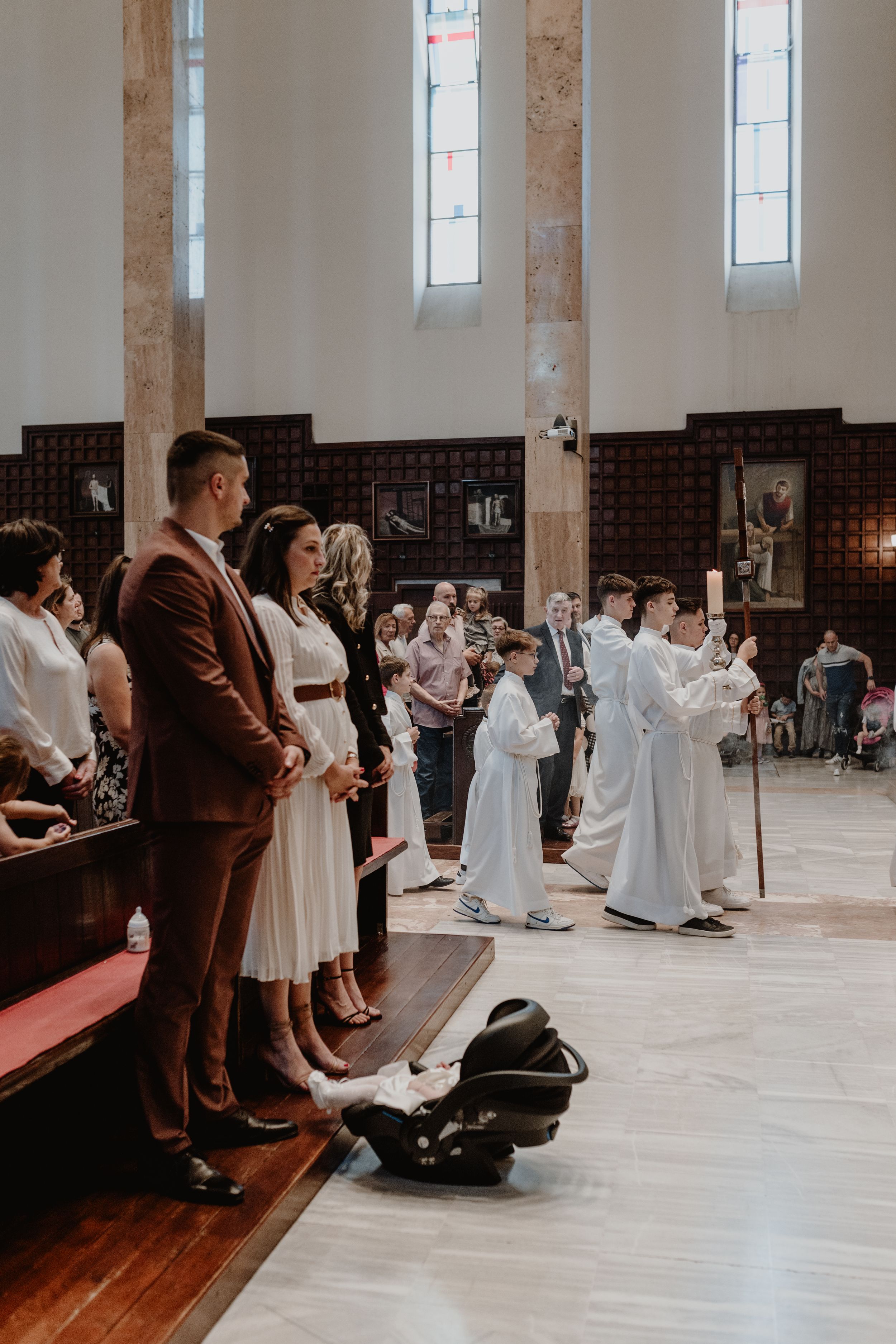Candid photo of family standing in prayer as the Holy Mass begins at their baby’s christening.