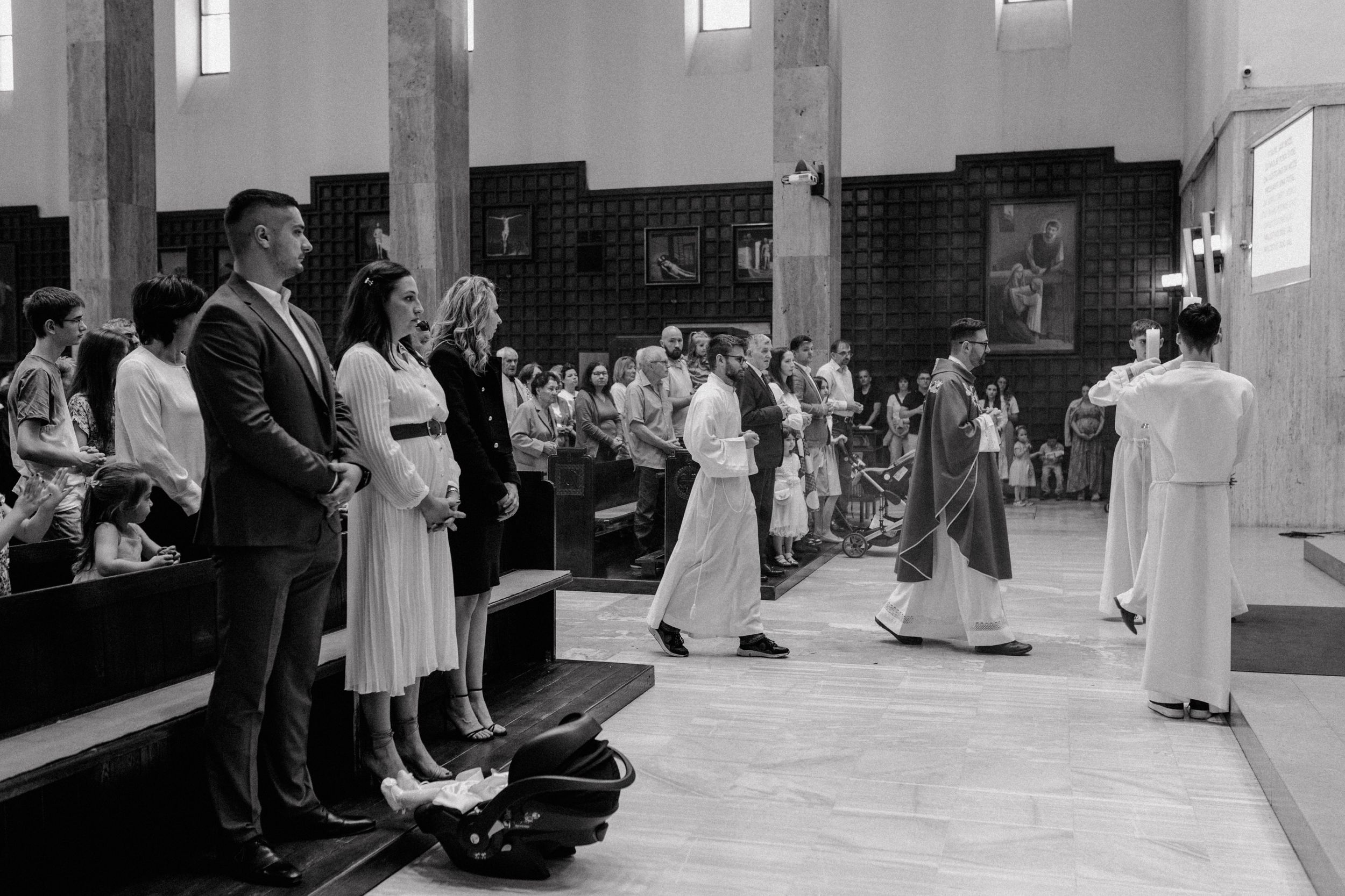 Family of four gathered in a church for their baby's christening ceremony.