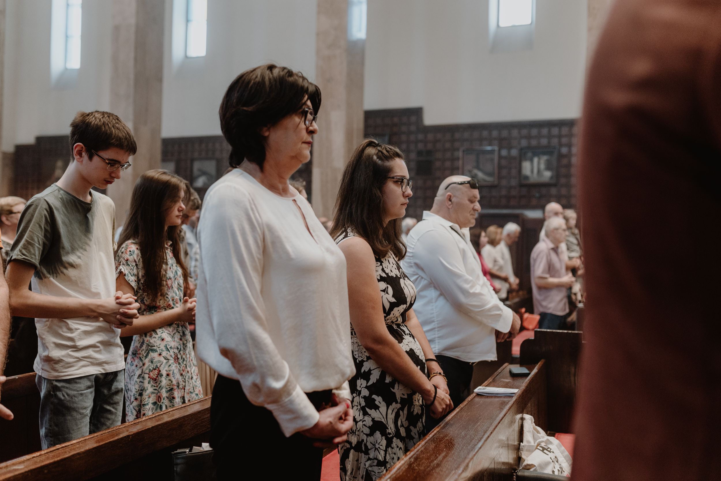 Grandparents seated in the second row, as they watch their grandchild’s christening, a moment filled with pride.