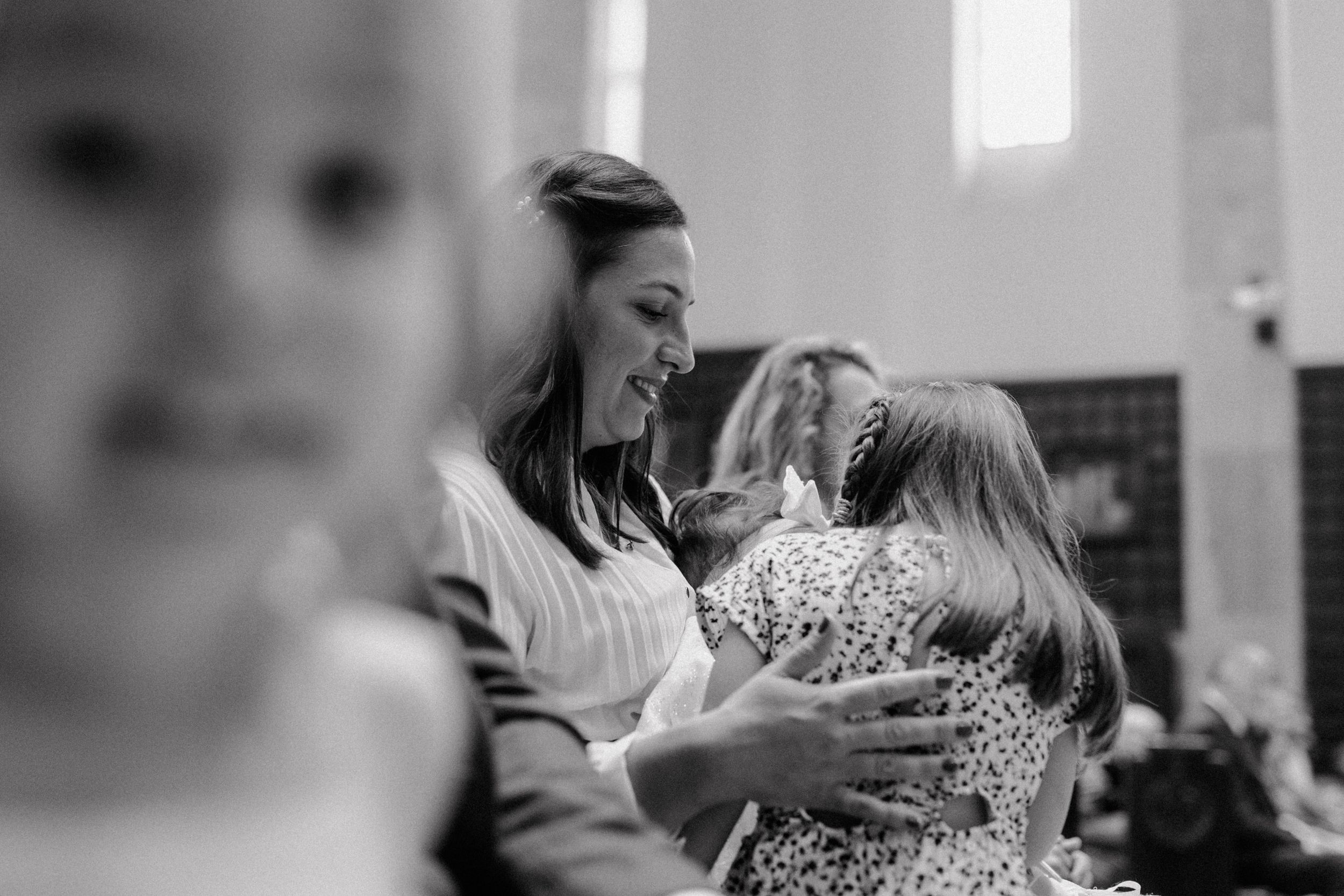 Black and white photo of children gathered around the baby and godmother in the front row during the christening.