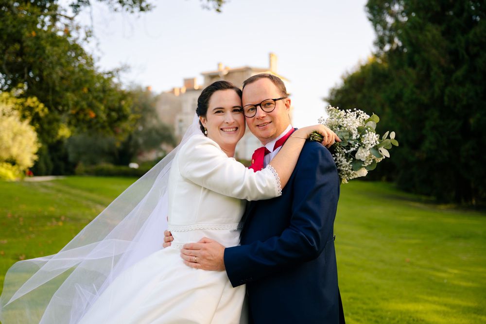 Romantic wedding couple embraces on a lush green golf course during sunset.