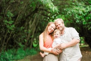 Family shares joyful moment together on wooded nature trail. Oahu Family Photographer