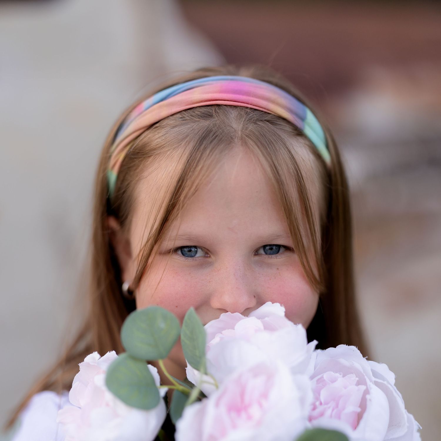 Close-up of pink peonies with eucalyptus leaves against a soft background.
