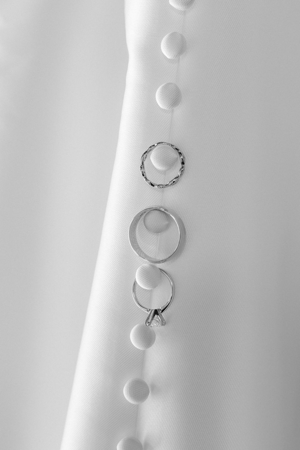 Water droplets arranged in a curved line create a minimalist pattern against a white background.