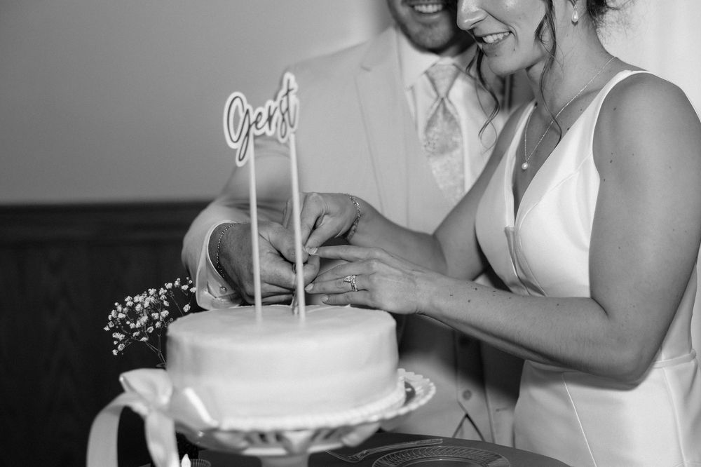 A collage of black and white wedding photos showing cake cutting moments and celebrations at a reception.
