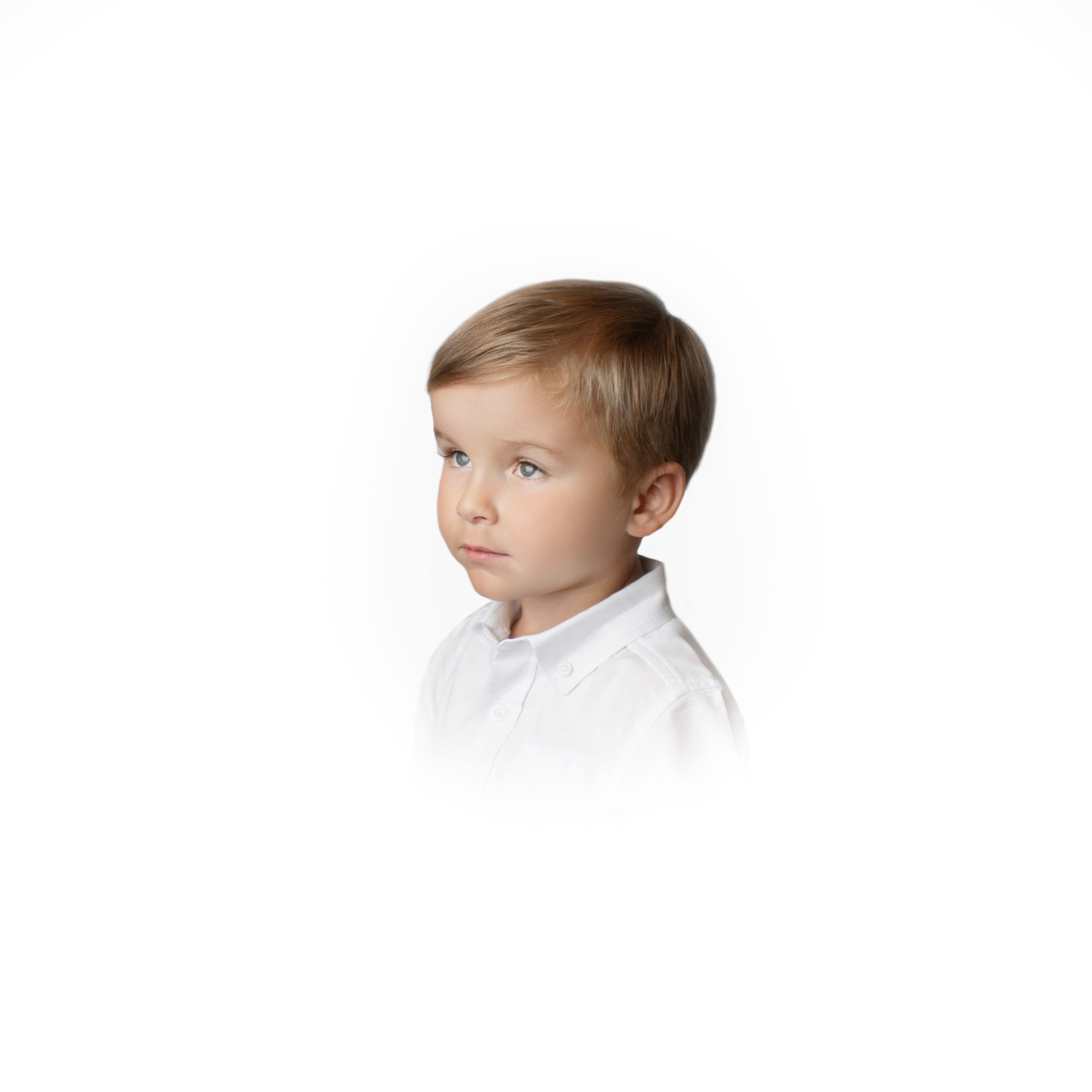 Studio portrait of young child in white shirt against light background.