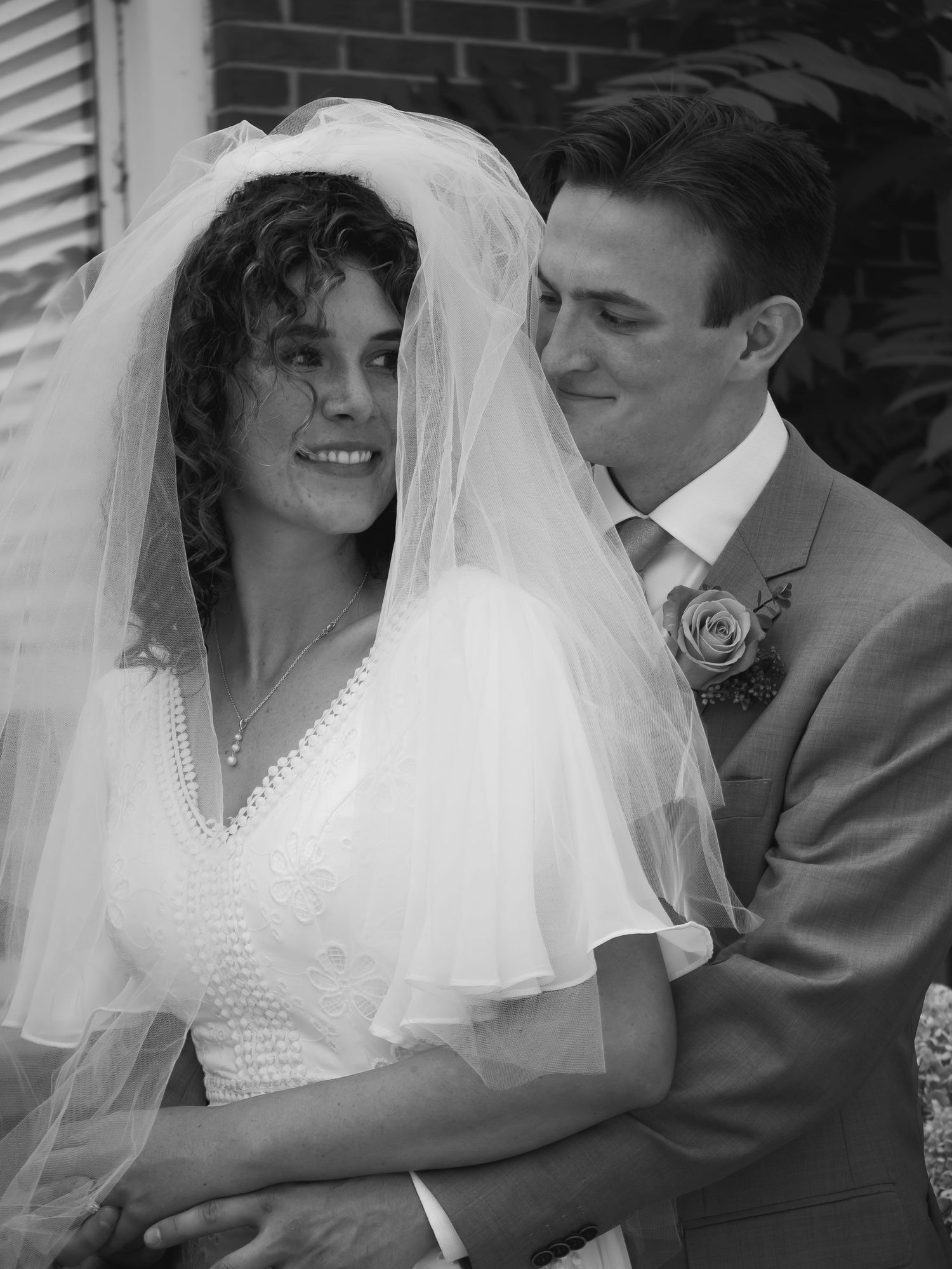 A romantic wedding portrait of a couple with the bride wearing a beautiful veil and white dress.