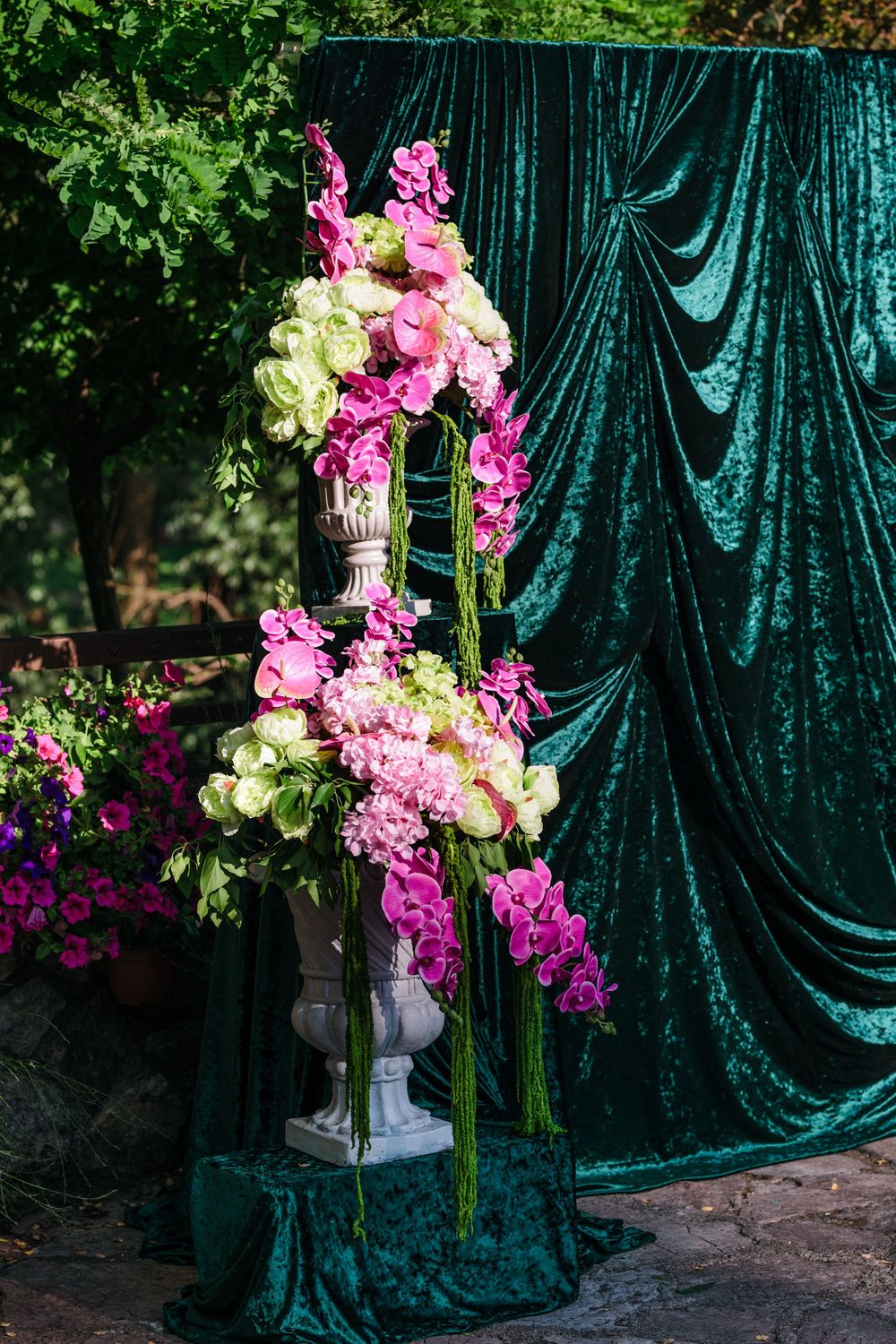 Beautiful floral arrangement with pink orchids and white hydrangeas against an elegant emerald green velvet backdrop.