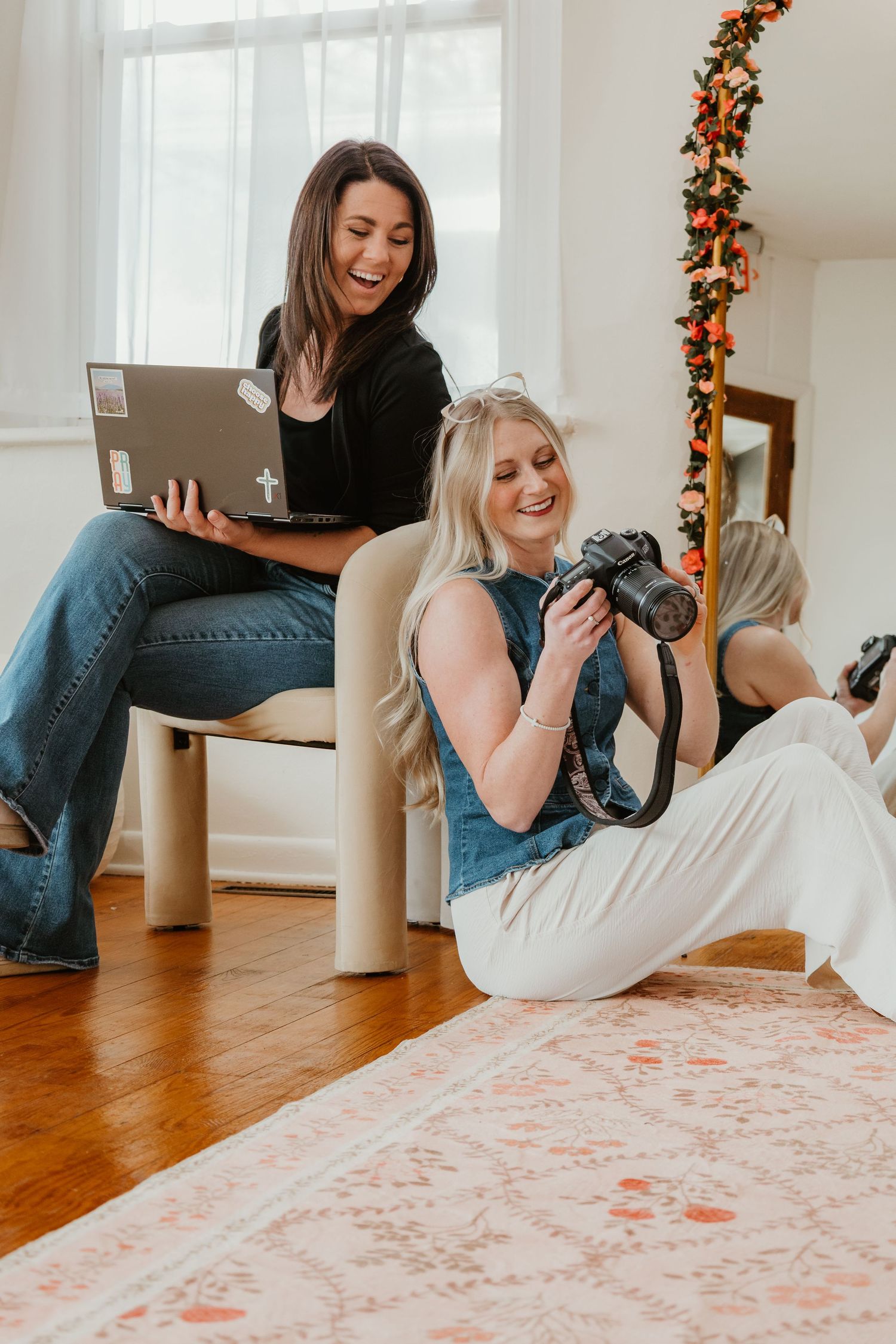 Indoor scene showing a photographer holding a vintage film camera in a modern living room setting with natural lighting.