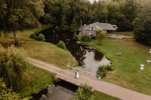 Un couple de mariés sur un pont au-dessus d'une rivière