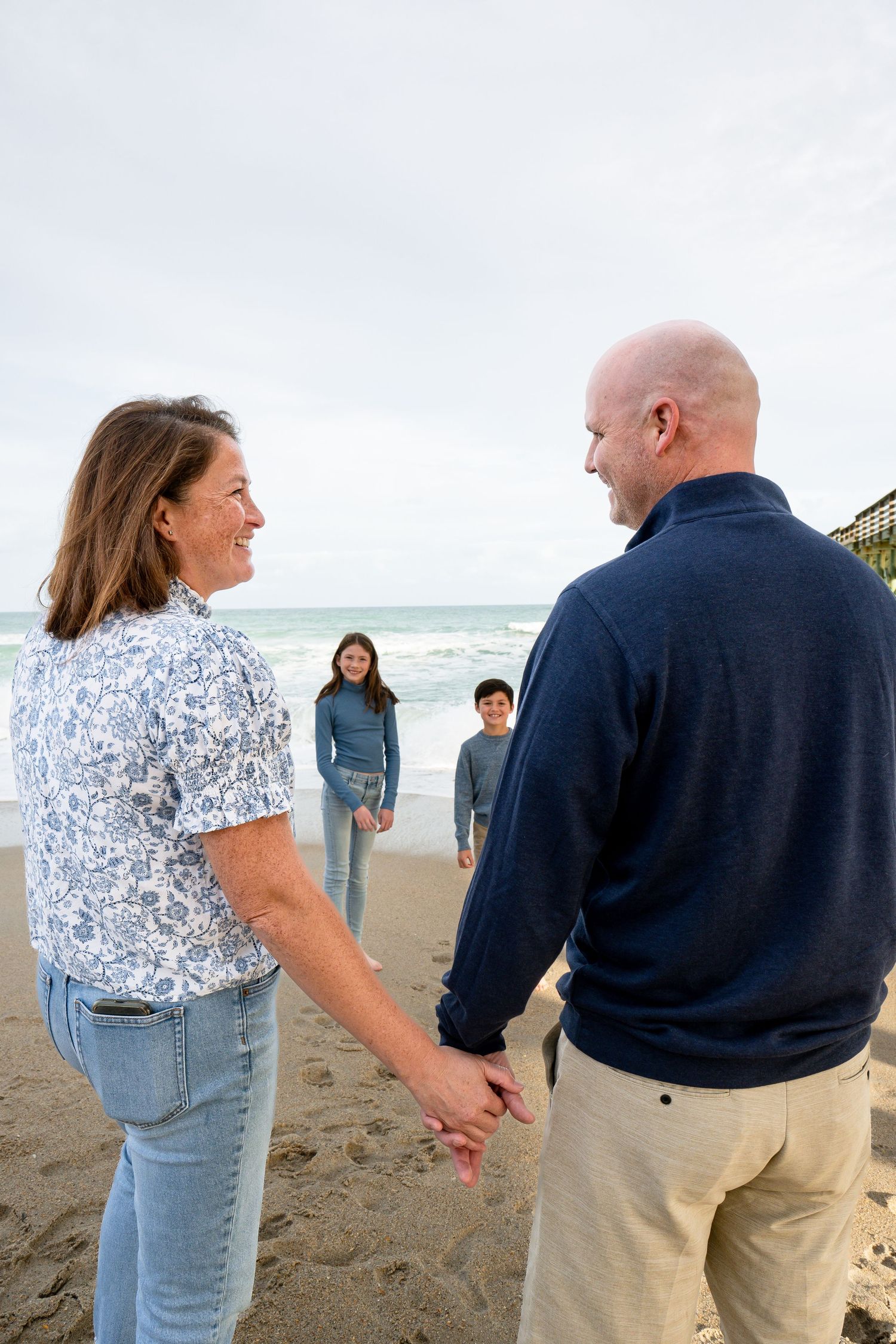 Family enjoying a sunset beach walk together along the ocean shore.