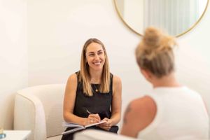Professional consultation meeting in a bright, modern office space with circular mirror.