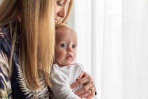 Tender moment of mother and son by window with soft natural lighting.