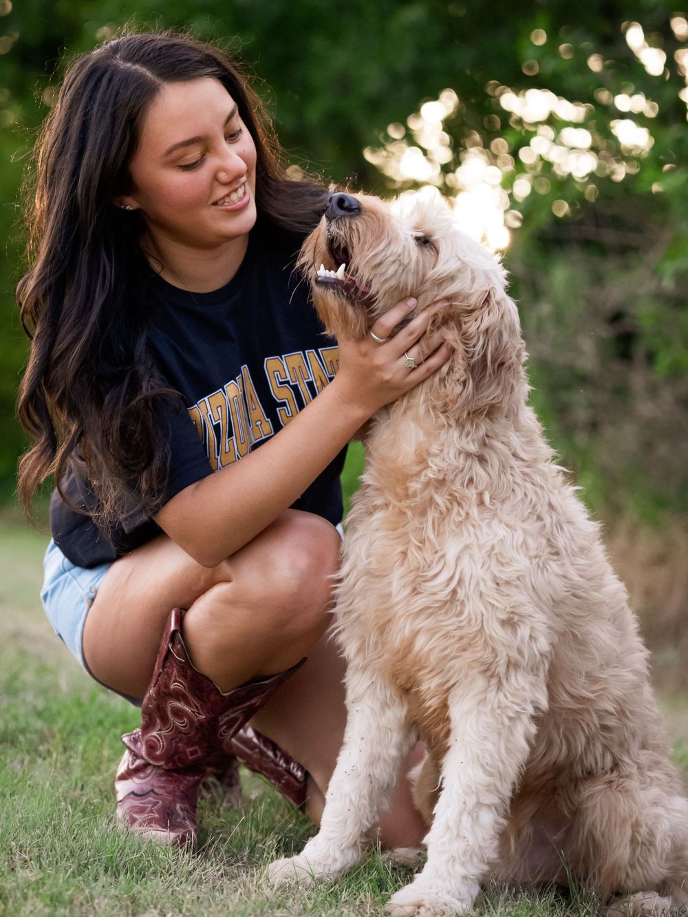 Sweet interaction with a cream-colored goldendoodle dog during an outdoor photoshoot.