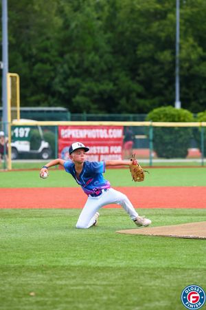 Baseball player diving to make a defensive play on an artificial turf field.